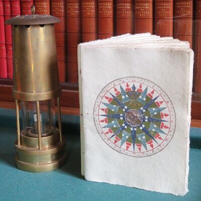 Cuaderno de papel pergamino con patrón de rosa de los vientos, astrolabio y tema marino