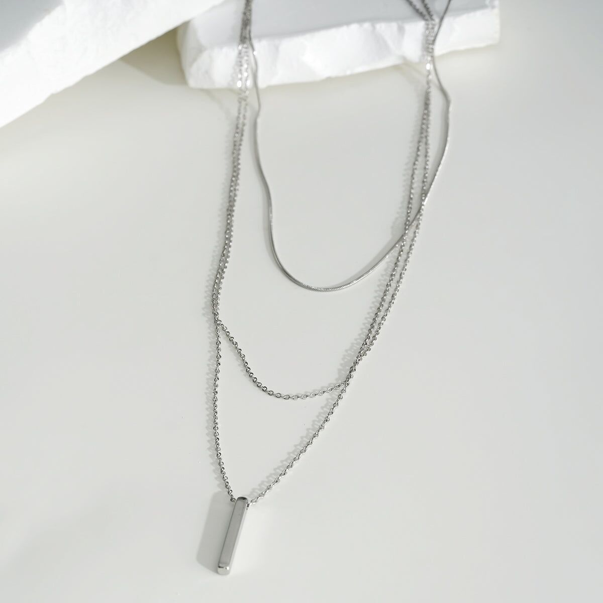 Collana in argento a tripla catena con serpente e maglie con pendente a barra