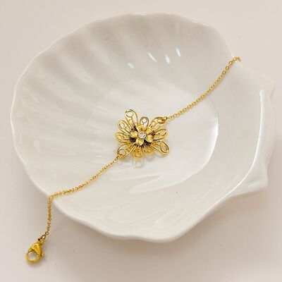 Pulsera de oro con flor y múltiples pétalos huecos engastados con pedrería