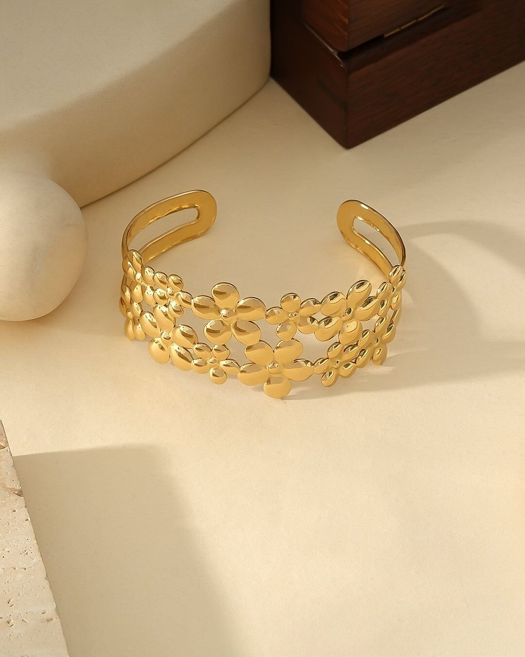 Bracciale in oro con polsino aperto e fasce a doppio fiore