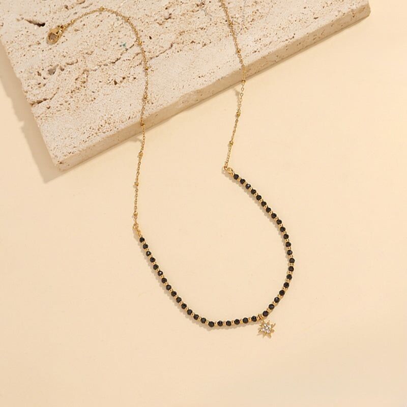 Collana in oro con catena di pietre di onice nero con pendente a stella in strass