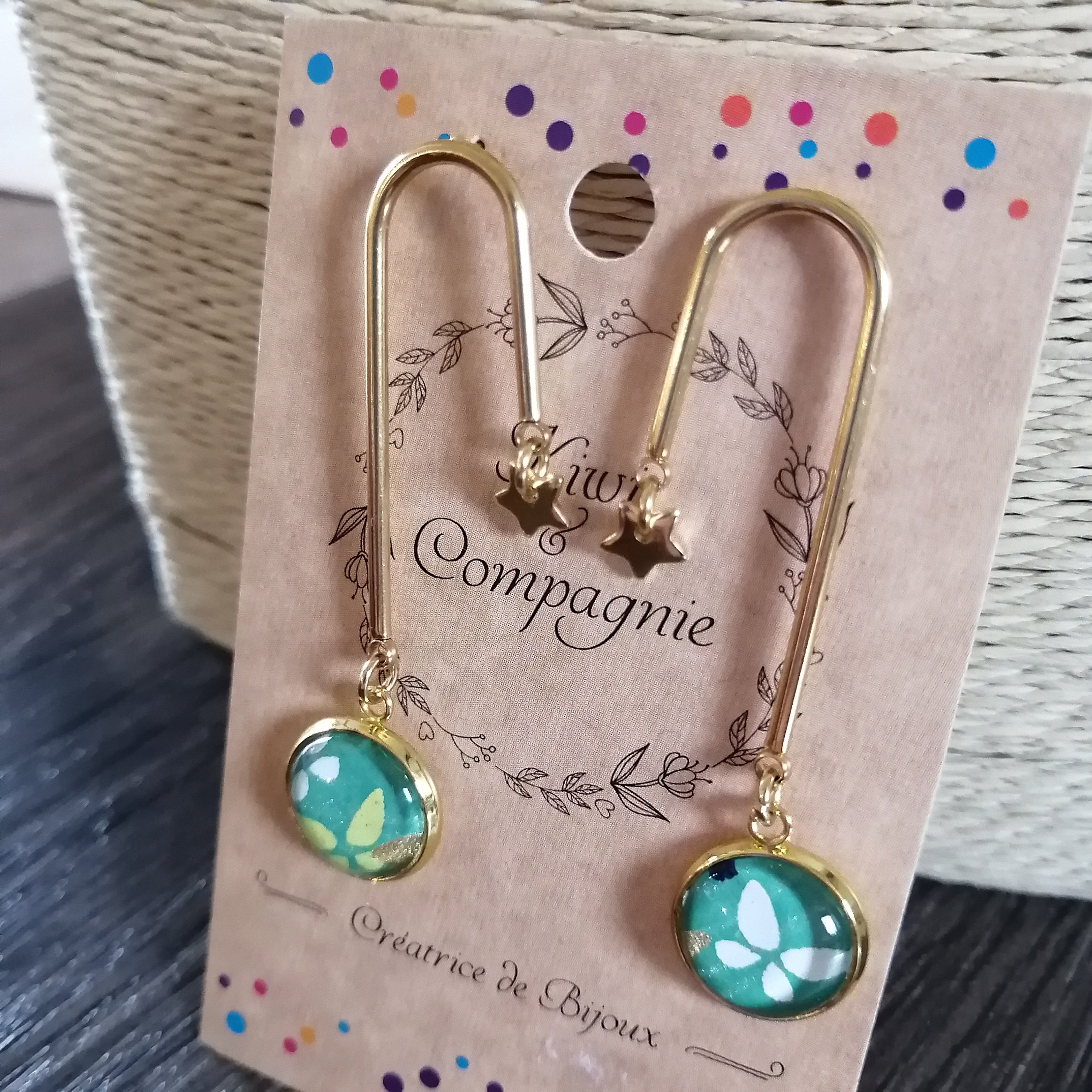 U-förmiger Ohrring – vergoldeter Edelstahl – Sternanhänger – weiße und grüne Schmetterlinge, jeansblauer Hintergrund