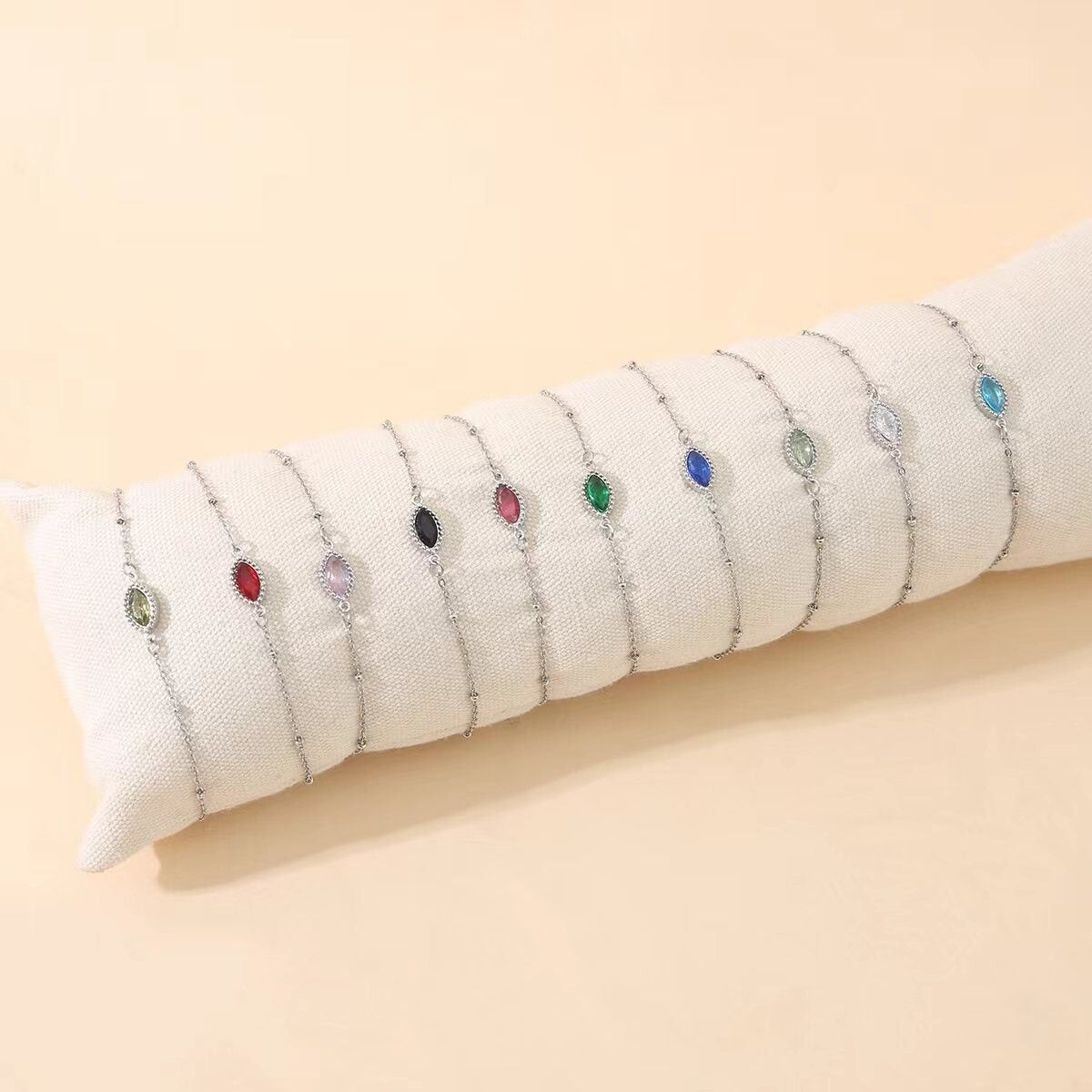 Set di 12 bracciali in argento con pietra ovale colorata su cuscino