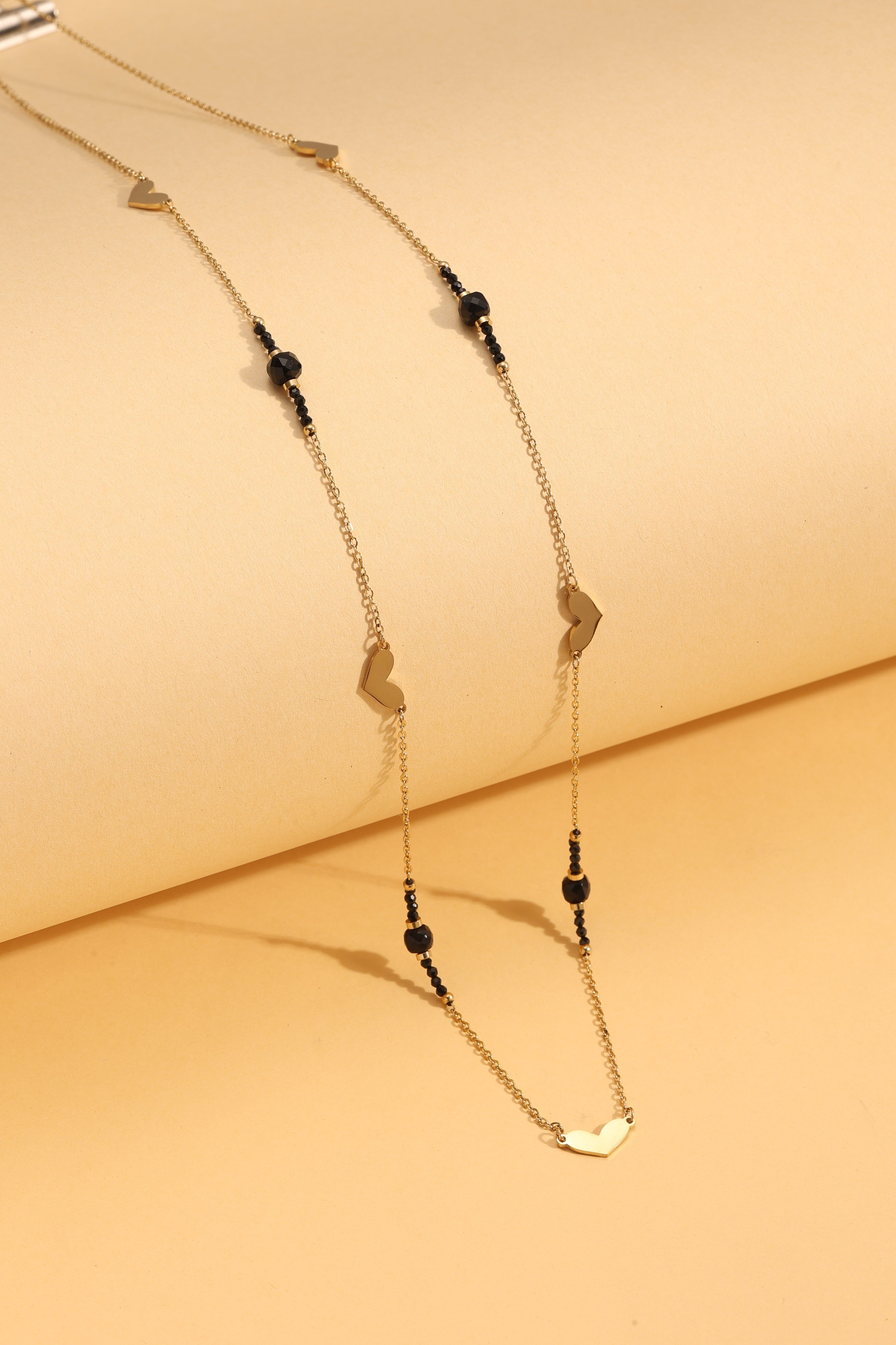 Goldene Sautoir-Halskette mit schwarzen Perlen und Herz