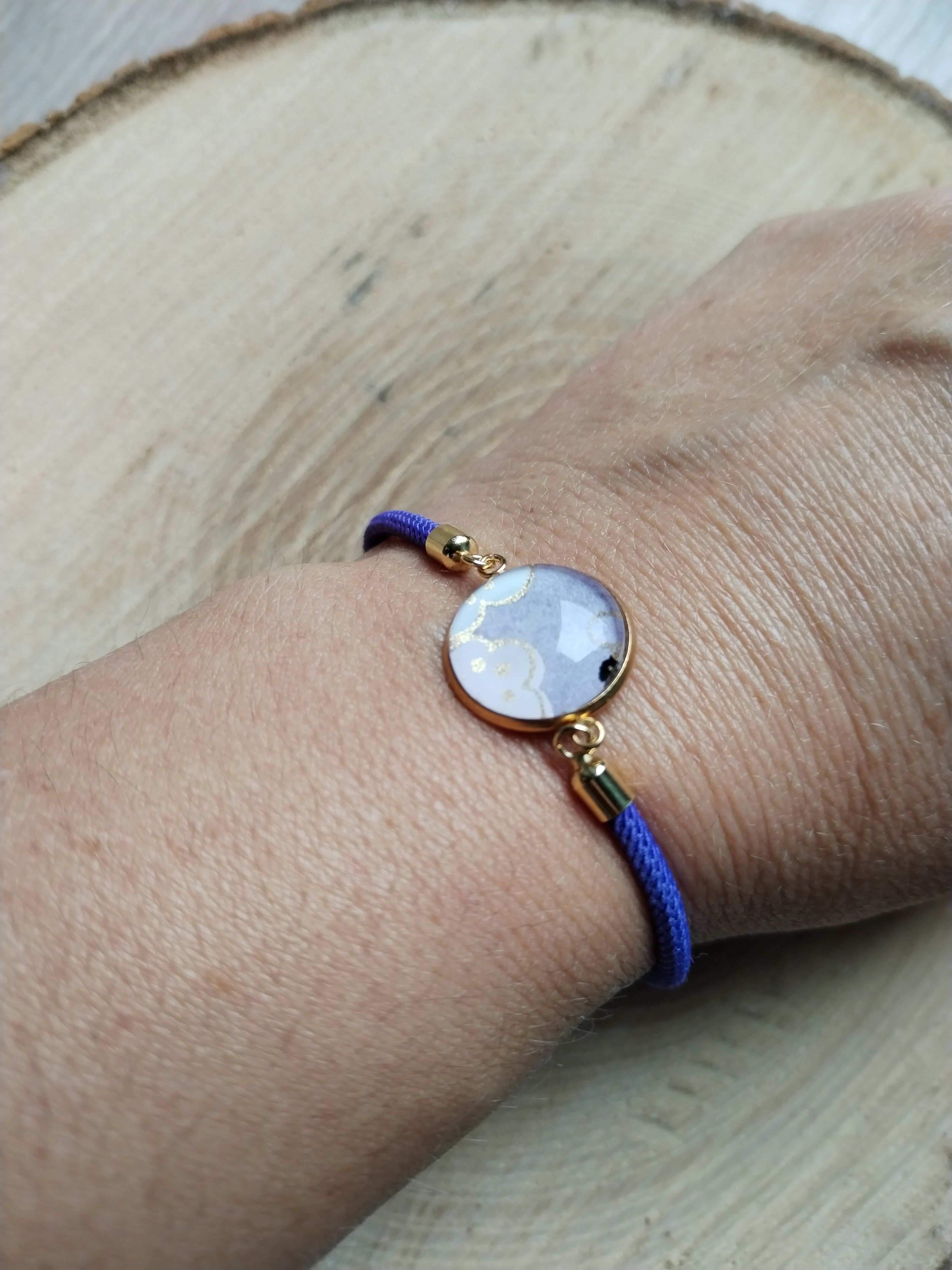 Verstellbares lila Baumwollarmband - weißer, goldener und lila Blumen-Cabochon