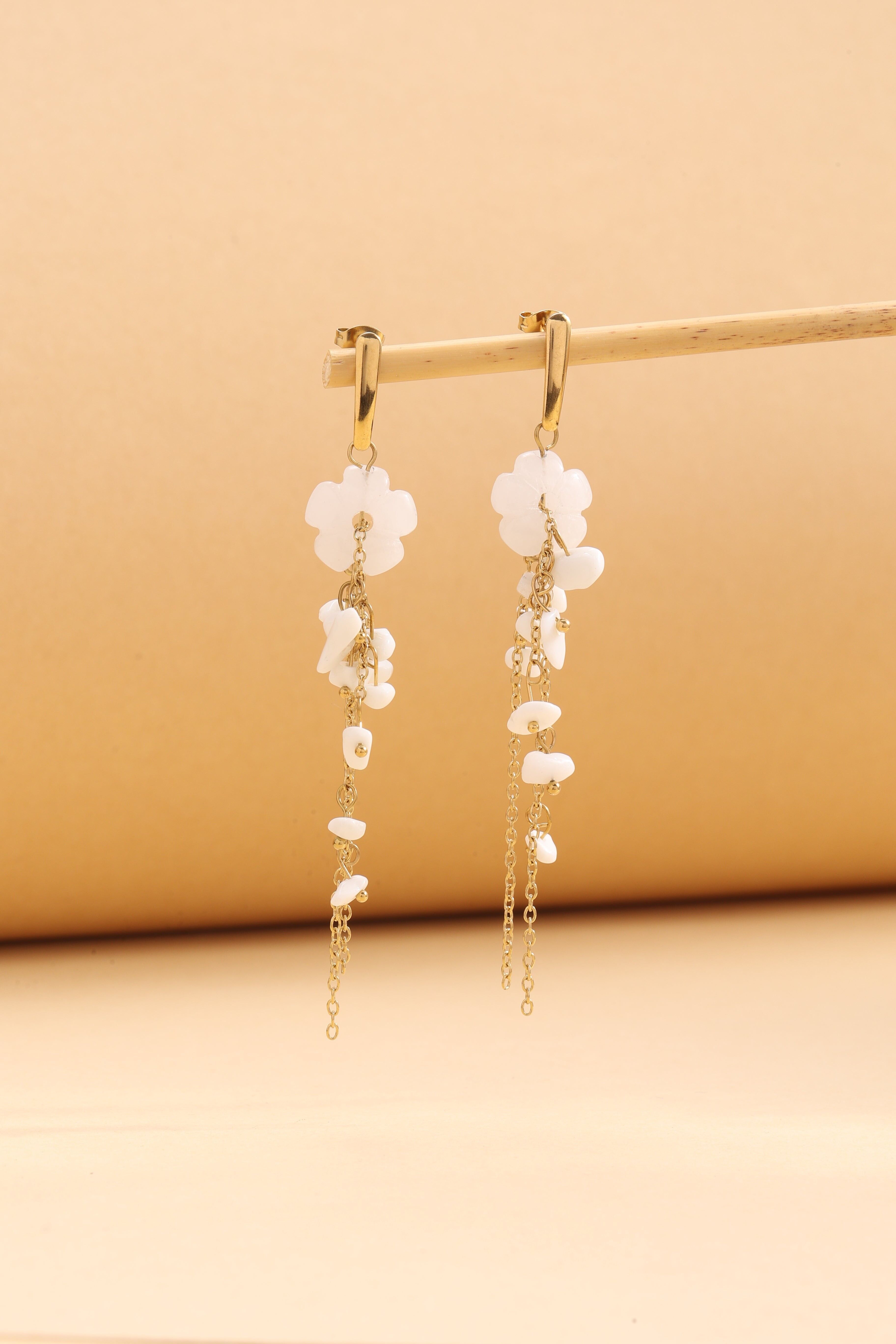 Orecchini pendenti in oro con fiore bianco e catene sottili con pietre naturali