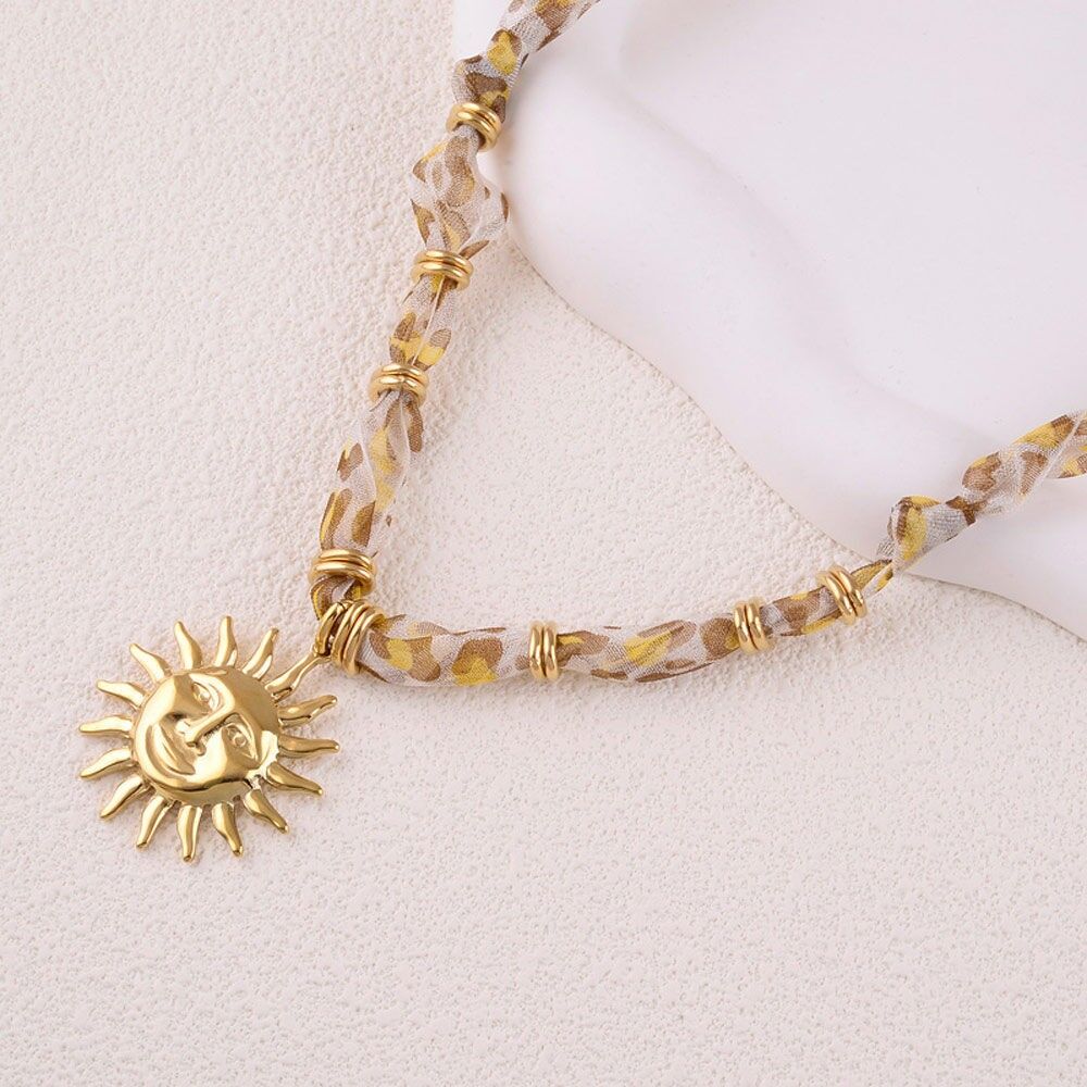 Delphina Halskette – Stoff, Stahlringe und Anhänger mit lächelnder Sonne