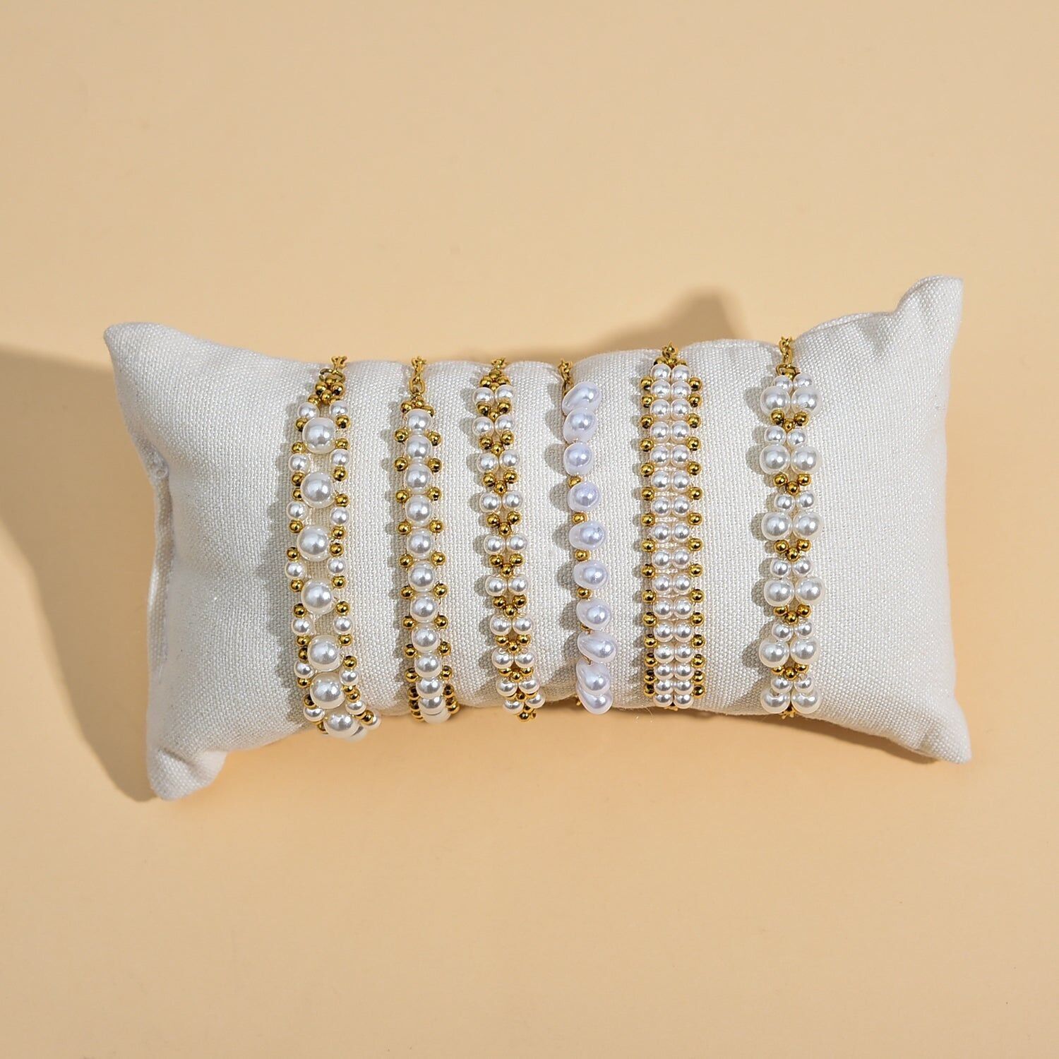 Set di 6 bracciali di perle bianche con dettagli in oro