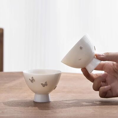 Taza maestra de porcelana blanca decorada con cierres de plata.