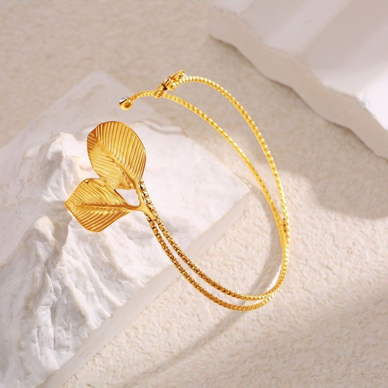 Offenes Armreif mit geformtem Blattwerk und Strassblume