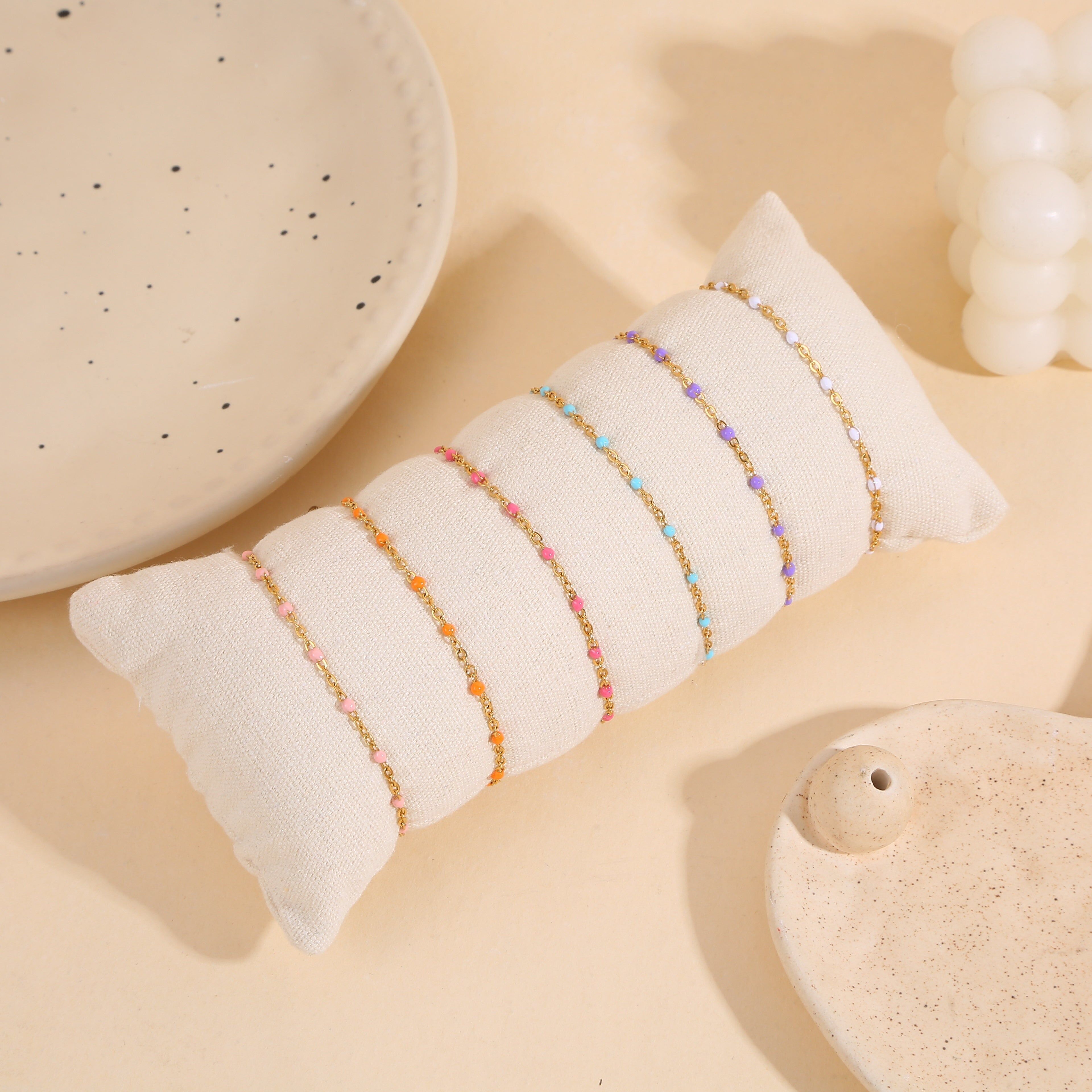 Set mit 6 pastellfarbenen Armbändern auf Kissen