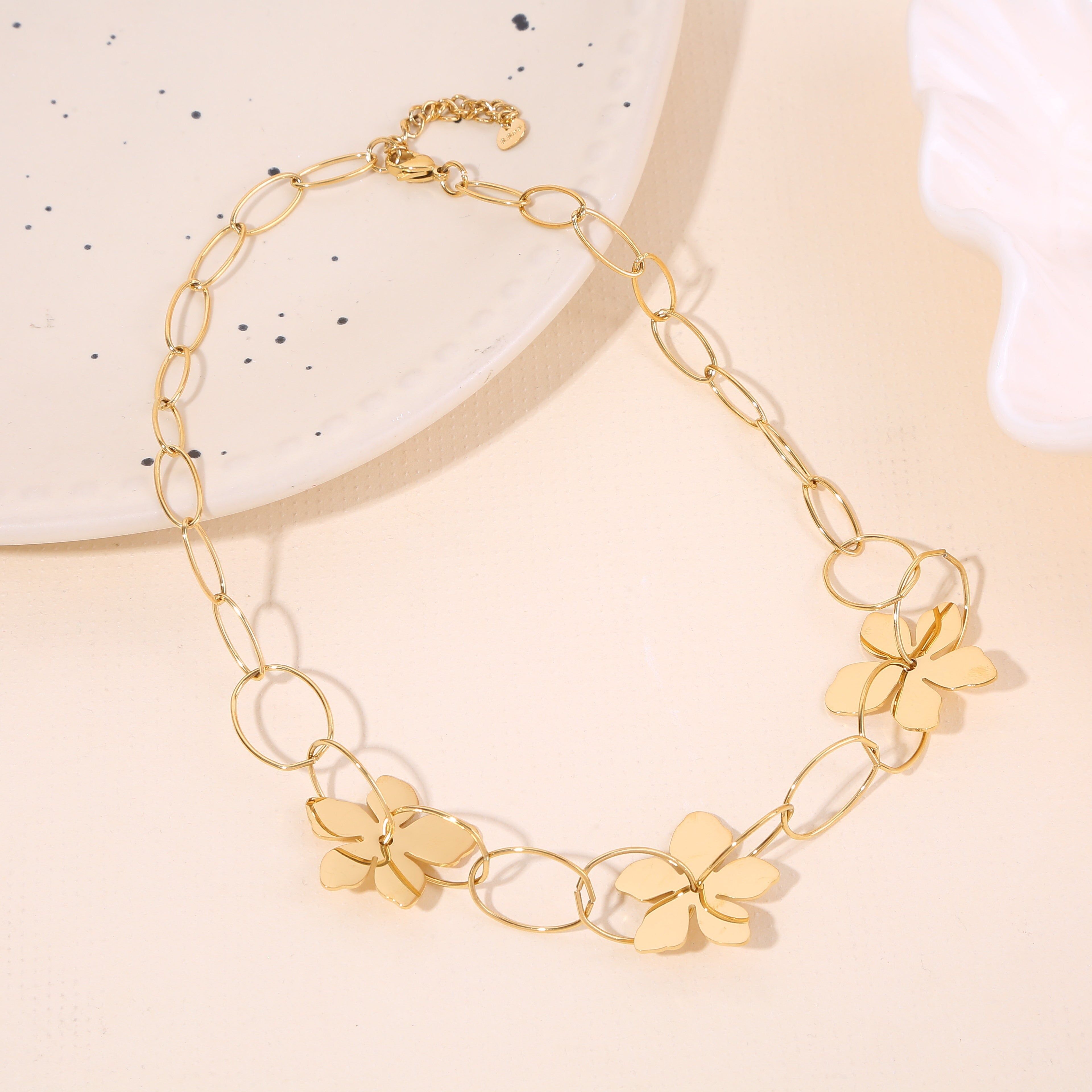 Collana con catena a maglie ovali in oro con fiori traforati lucidi