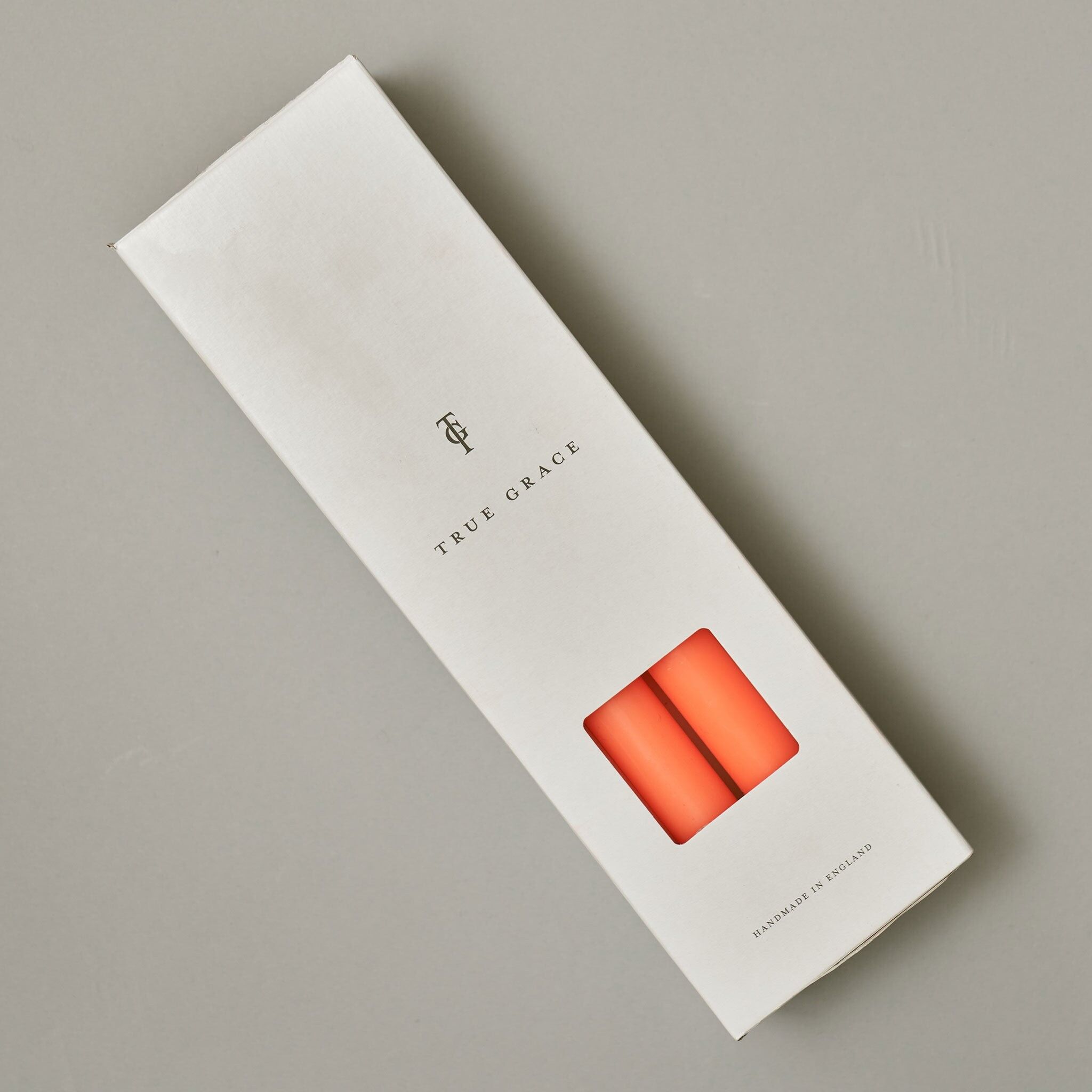 Fluoro-orangefarbene Schachtel mit 12 Stabkerzen – Brenndauer 12 Stunden