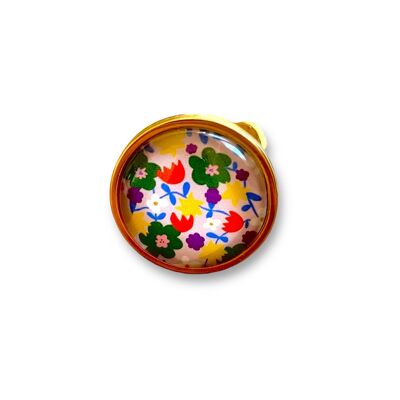 Anello con fiore multicolore su sfondo rosa chiaro con finitura oro o argento