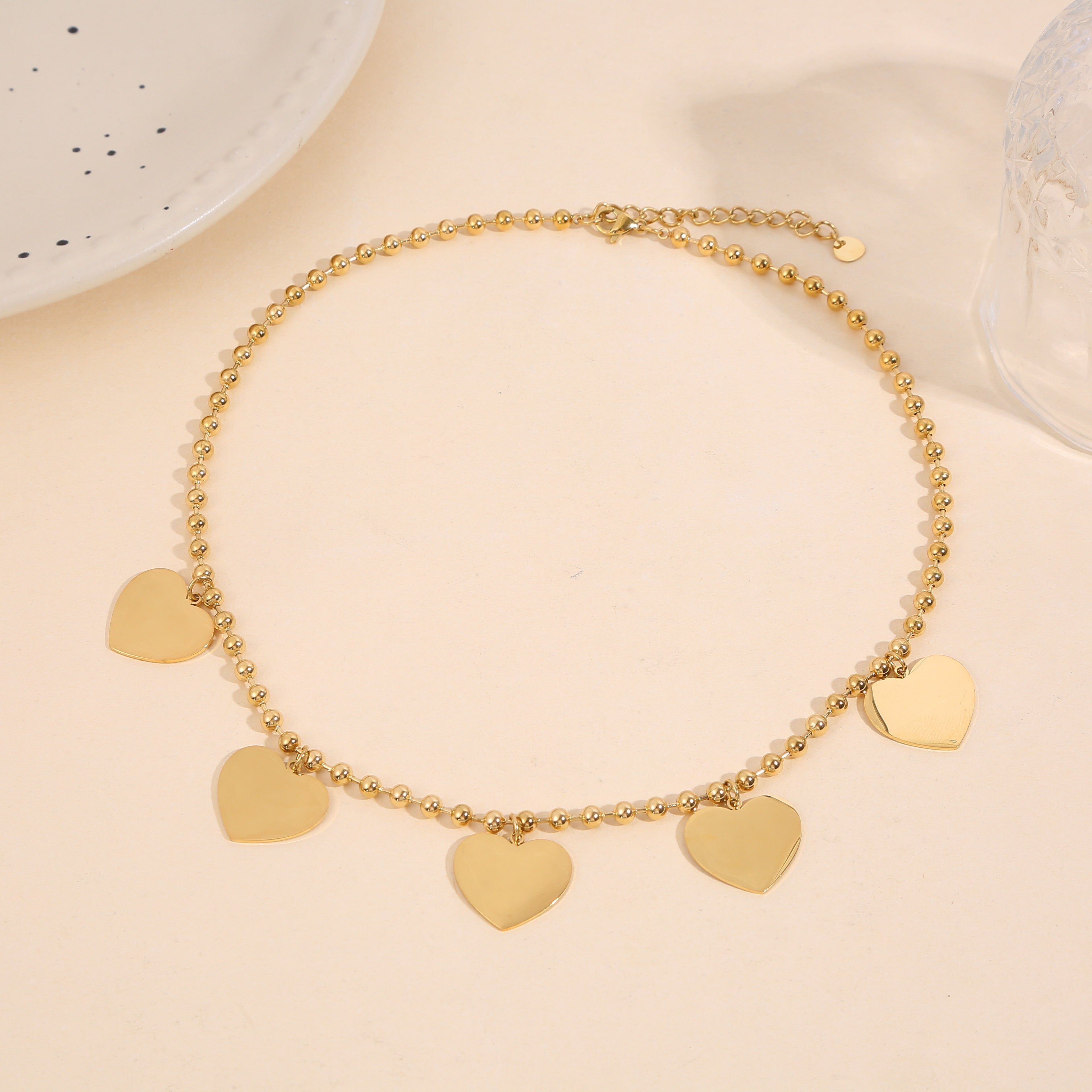 Collana con catena a palline in oro e nappe a cuore