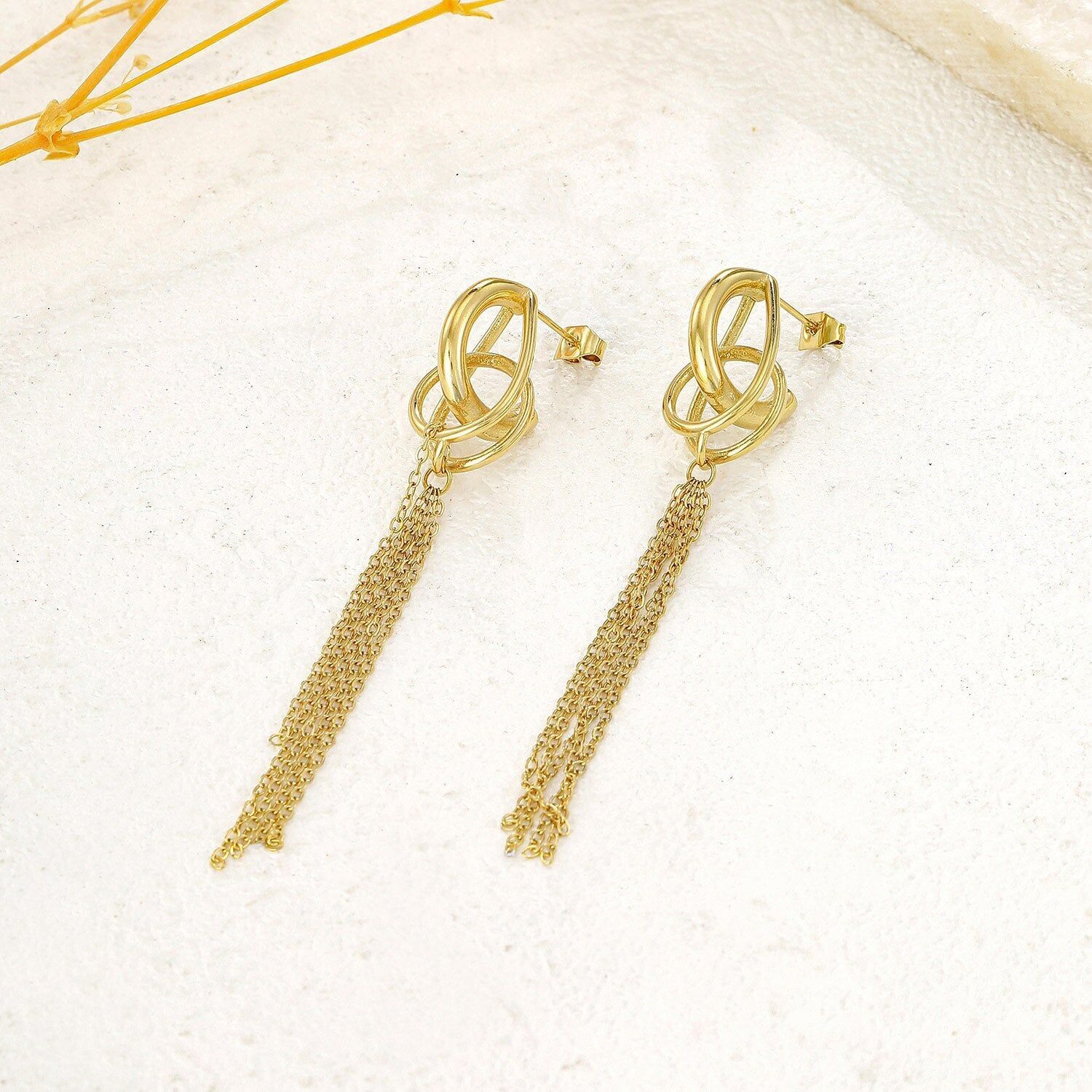 Orecchini pendenti in oro con anelli annodati e nappe a catena