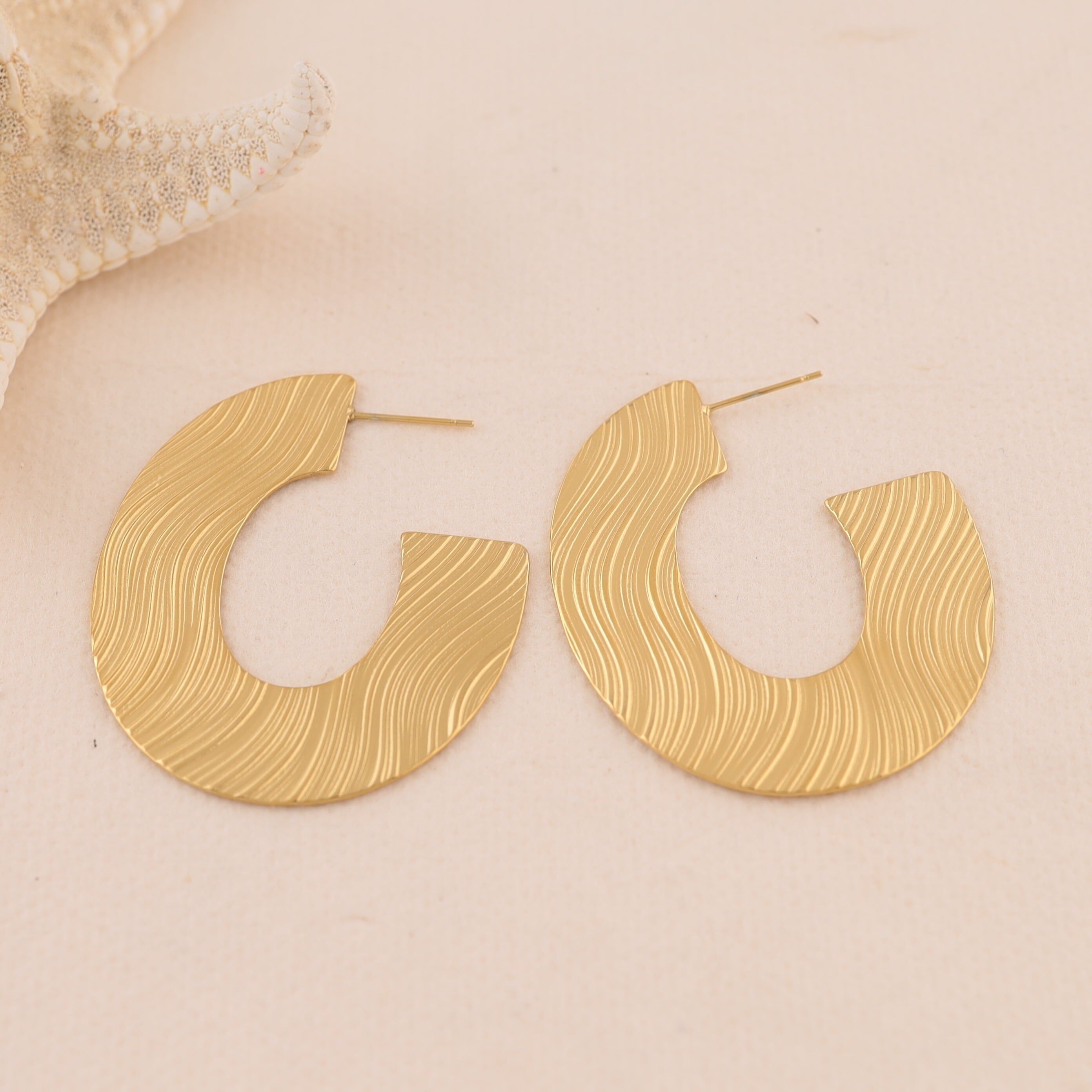 Orecchini a mezzo cerchio in oro con incisione ondulata