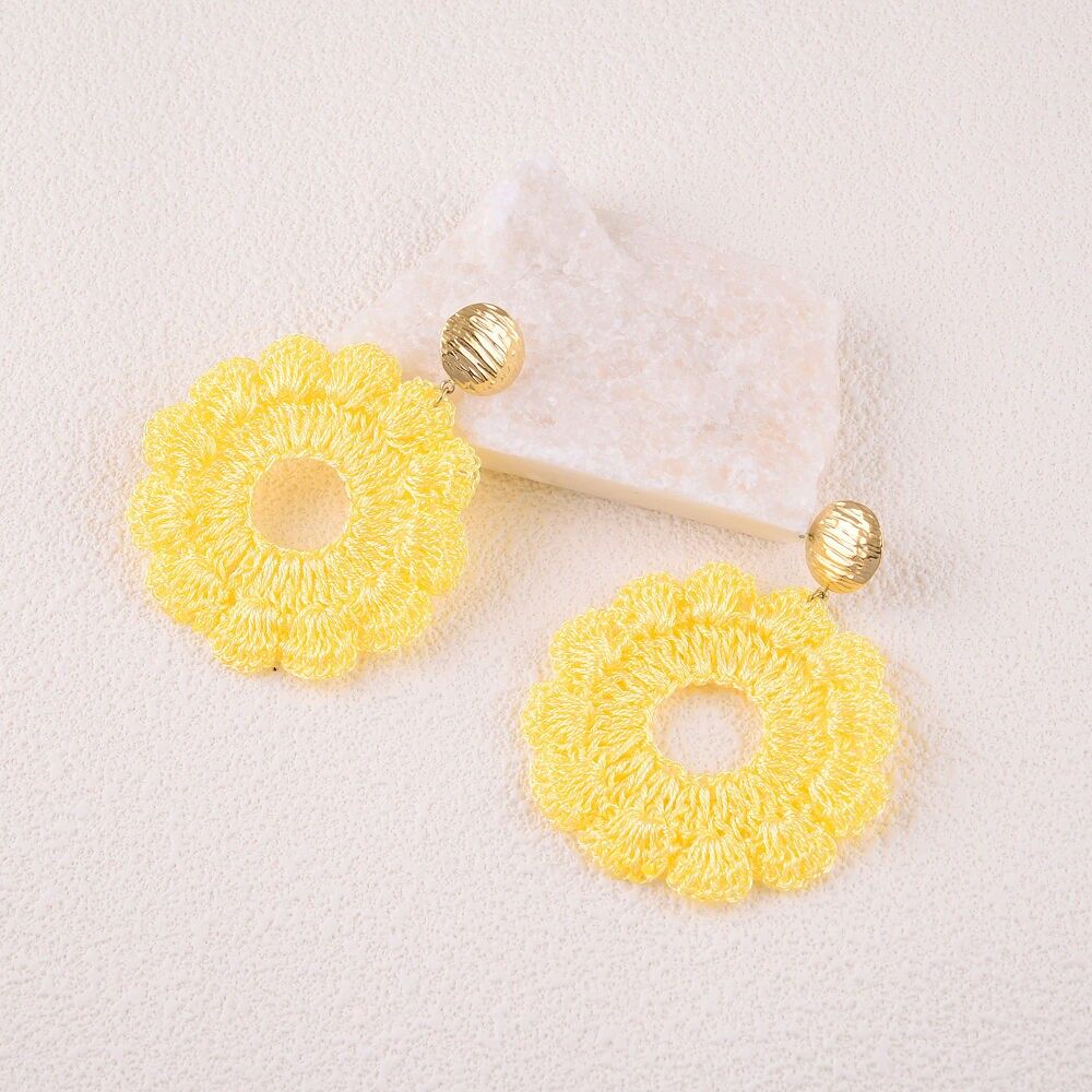 Hängende Ohrringe - rundes Stück und geflochtenes Stoffstück bilden eine Blume