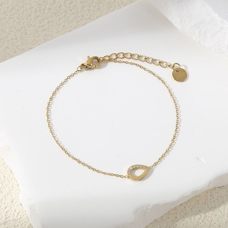 Bracciale dorato regolabile con anello a goccia tempestato di strass