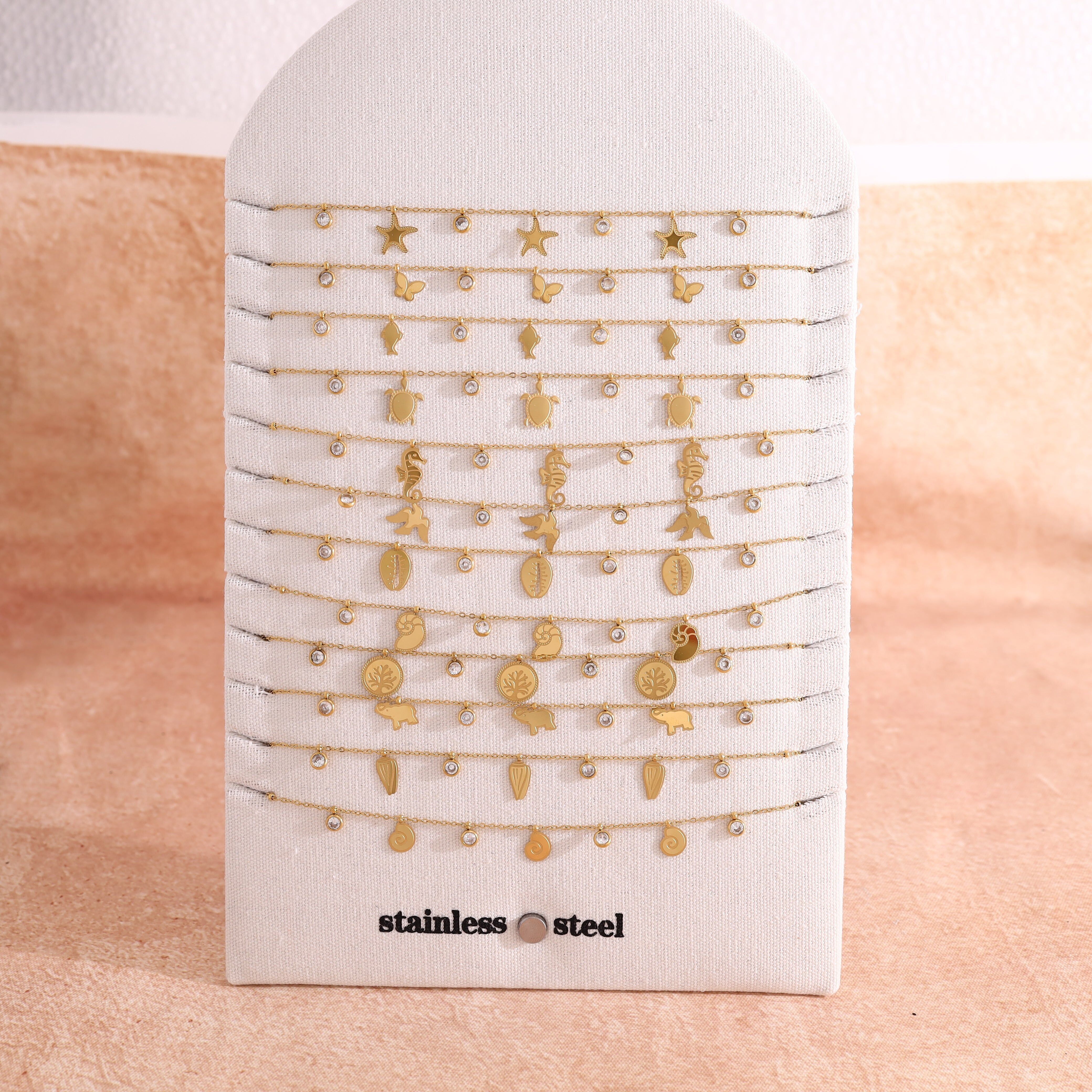 Set di 12 collane dorate a tema oceano in esposizione