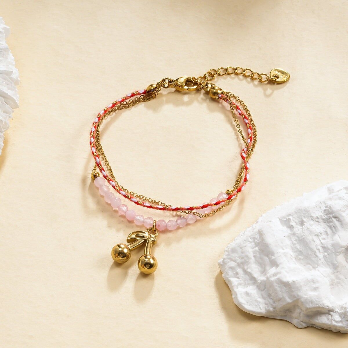 Bracciale a tripla catena in oro con filo rosso e ciondolo a forma di ciliegia