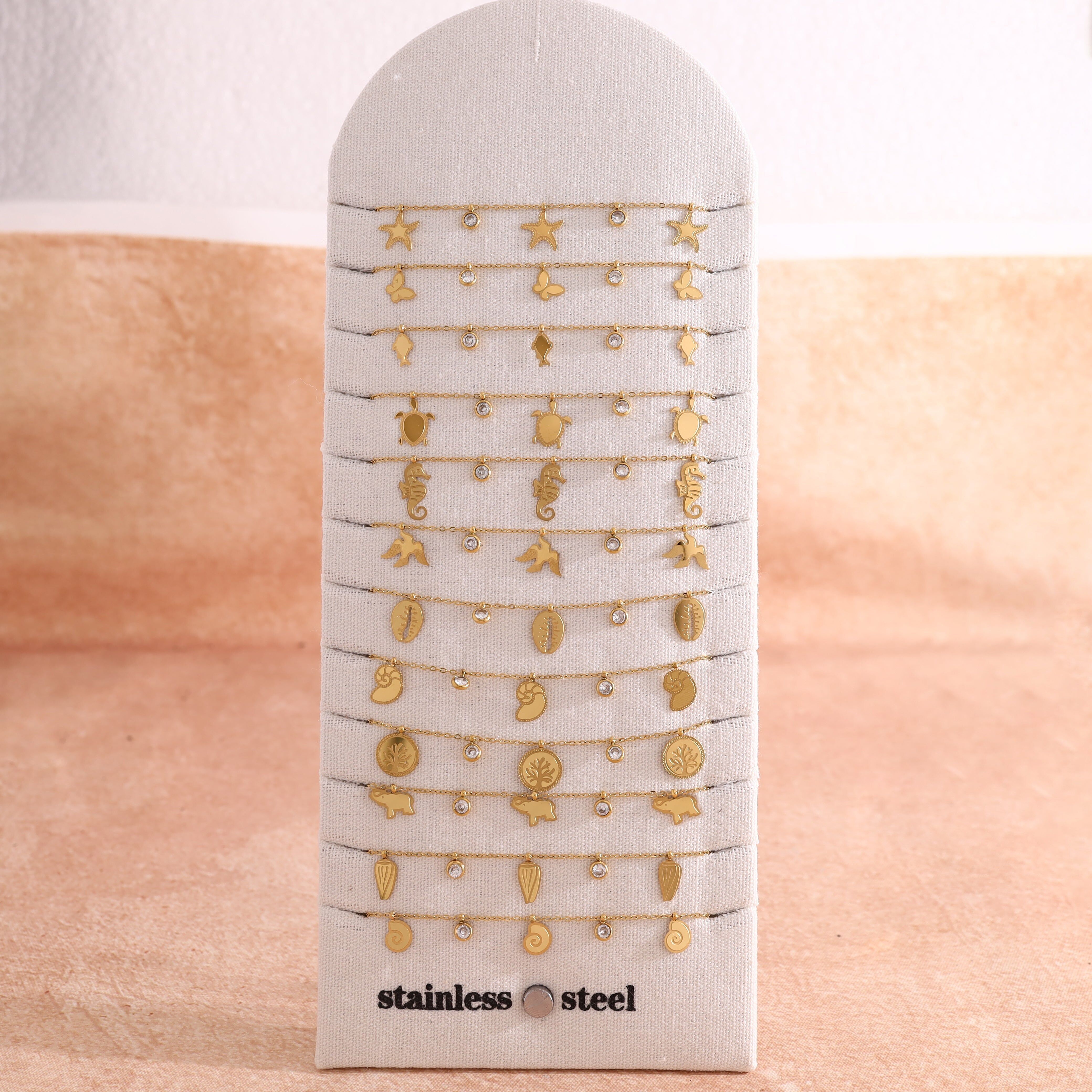 Set di 12 braccialetti dorati a tema oceano in esposizione