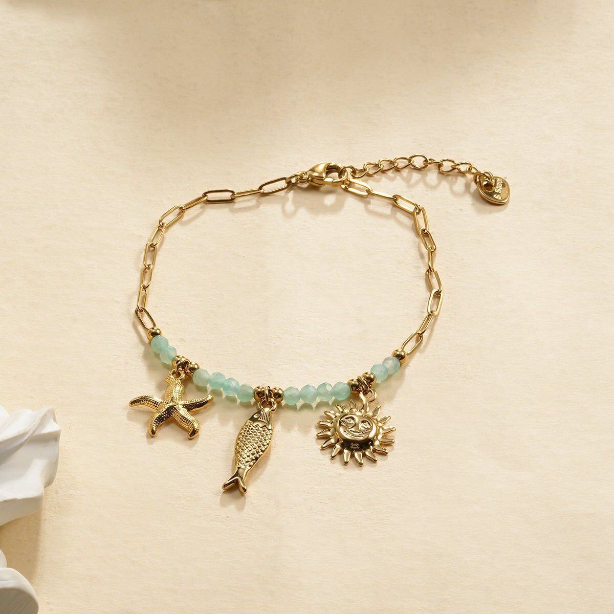 Bracciale in oro con pietra blu e ciondoli tripli a forma di pesce sole e stella marina