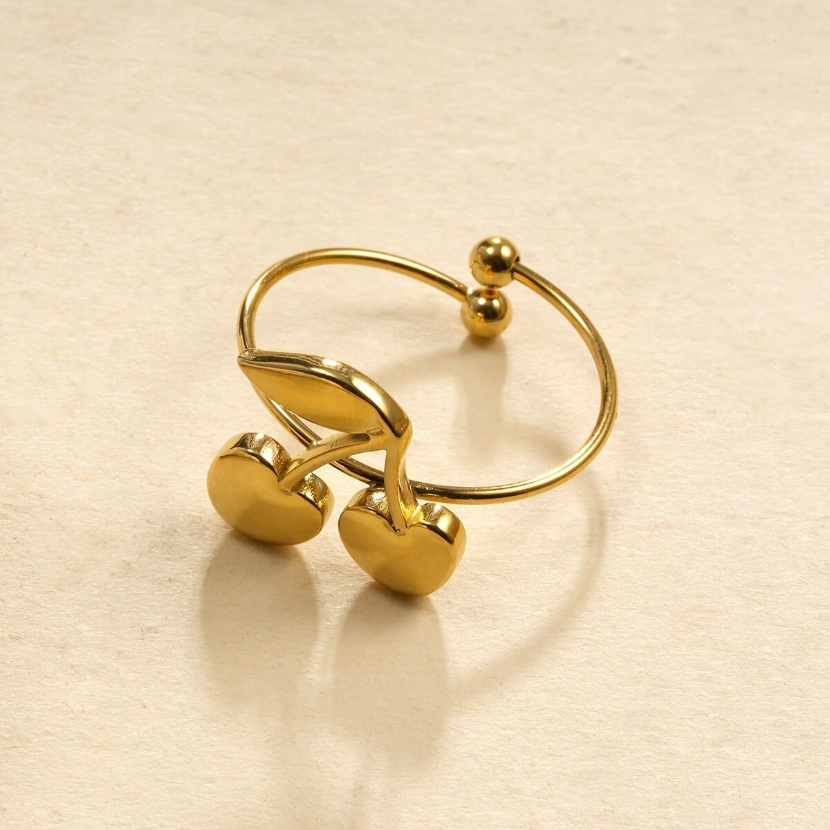 Sottile anello dorato con grande ciliegia