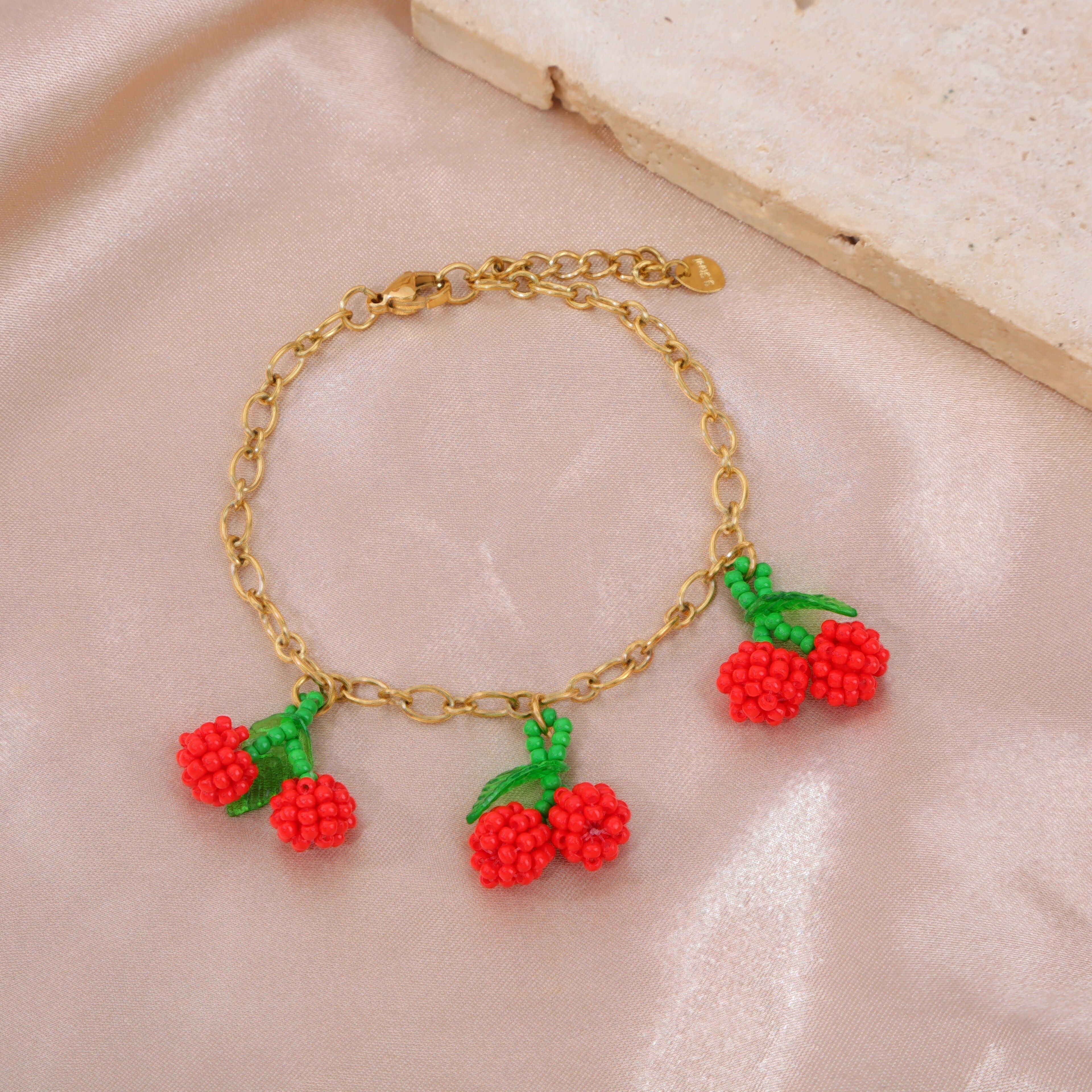 Bracciale in oro con ciondoli a forma di ciliegia intrecciata tripla