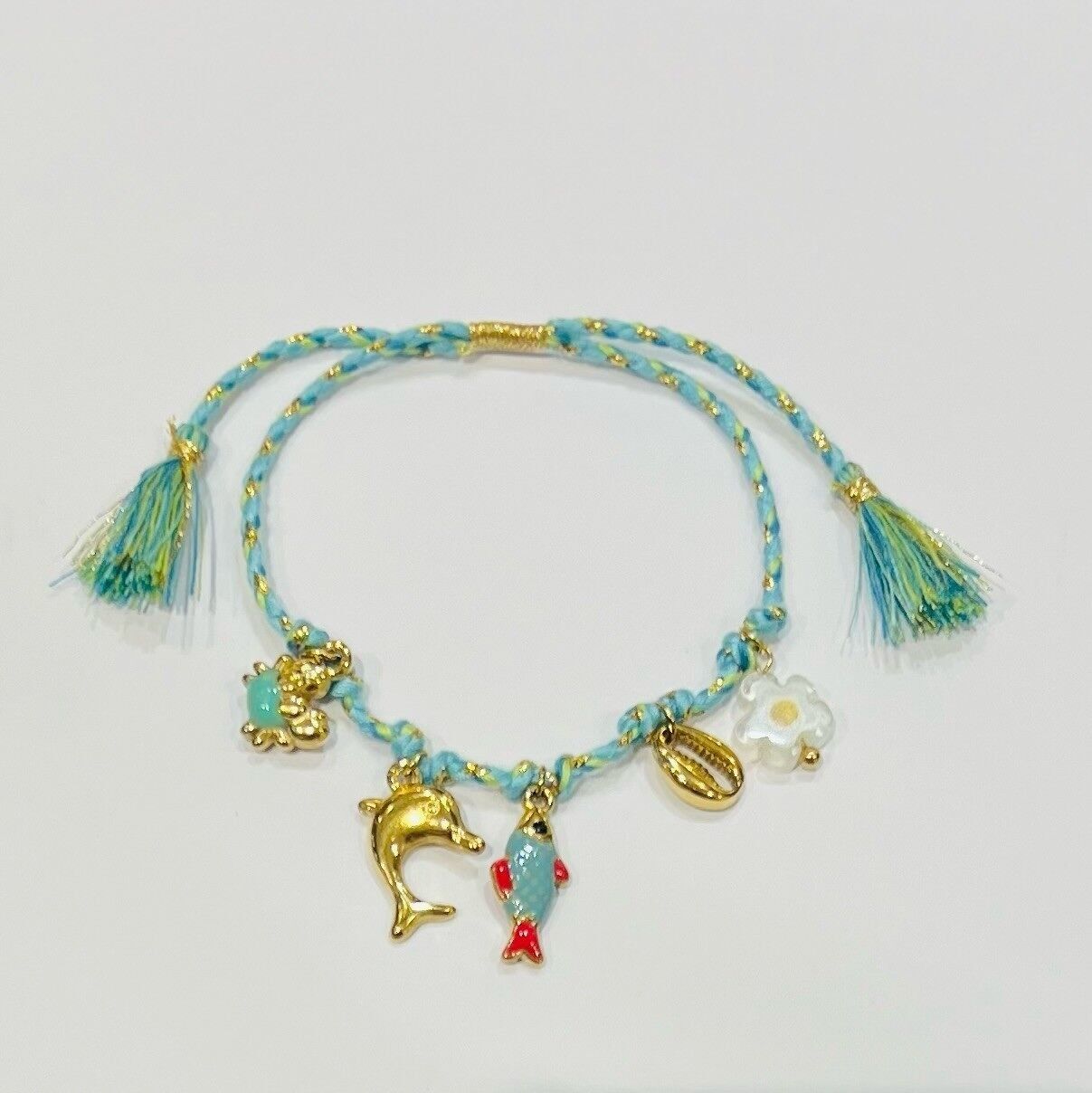 Bracciale in cordino d'acciaio con pompon, ciondoli a forma di delfino e sirena