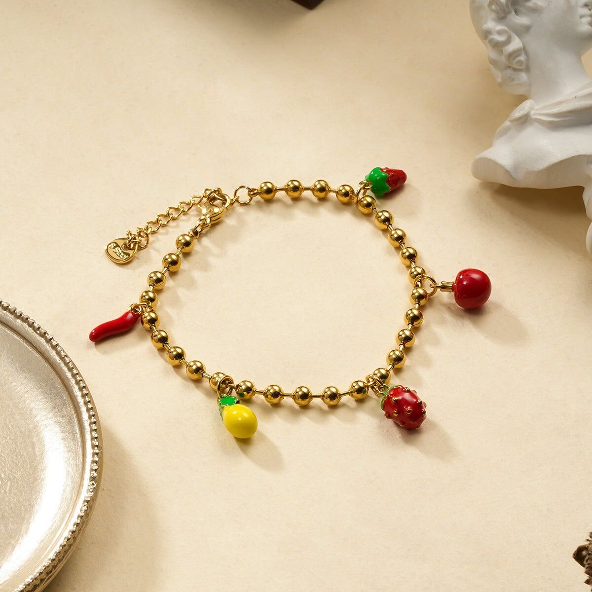 Bracciale con palline dorate a tema frutta