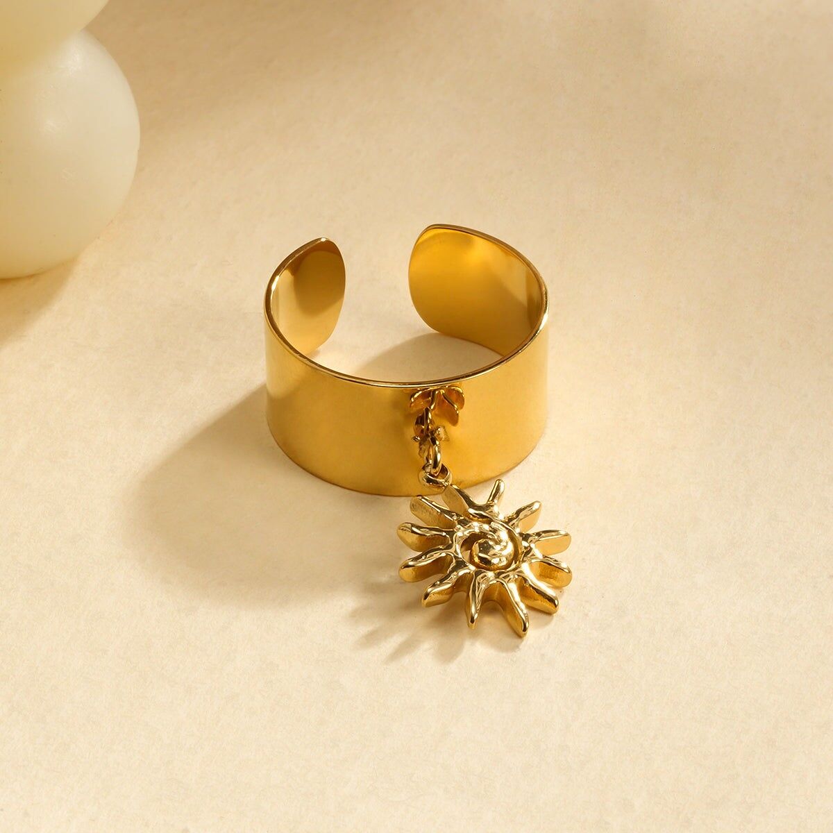 Grande anello dorato con ciondolo a forma di sole a spirale