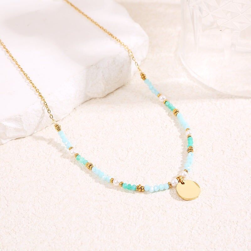 Collana in oro con cristalli blu e ciondolo a placca rotonda