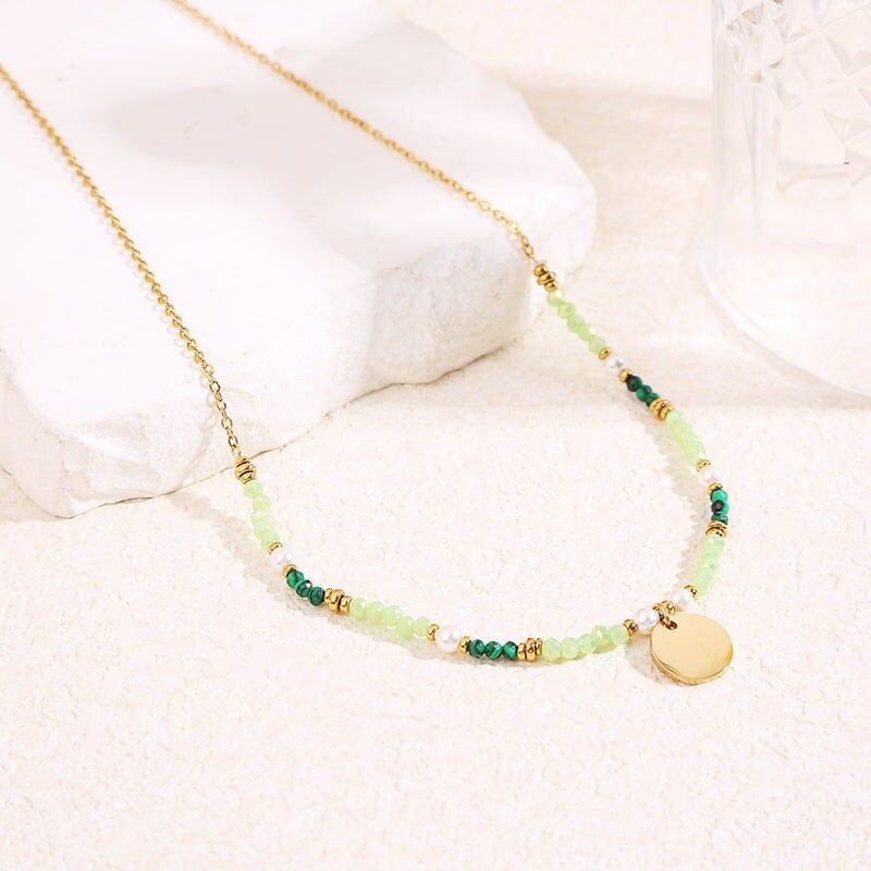 Collana in oro con cristalli verdi e ciondolo a piastra rotonda