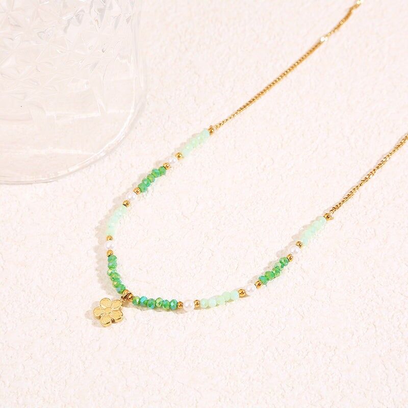 Collana in oro con cristalli verdi e ciondolo a forma di fiore