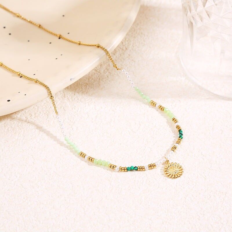 Collana in oro con cristalli verdi e ciondolo a forma di margherita