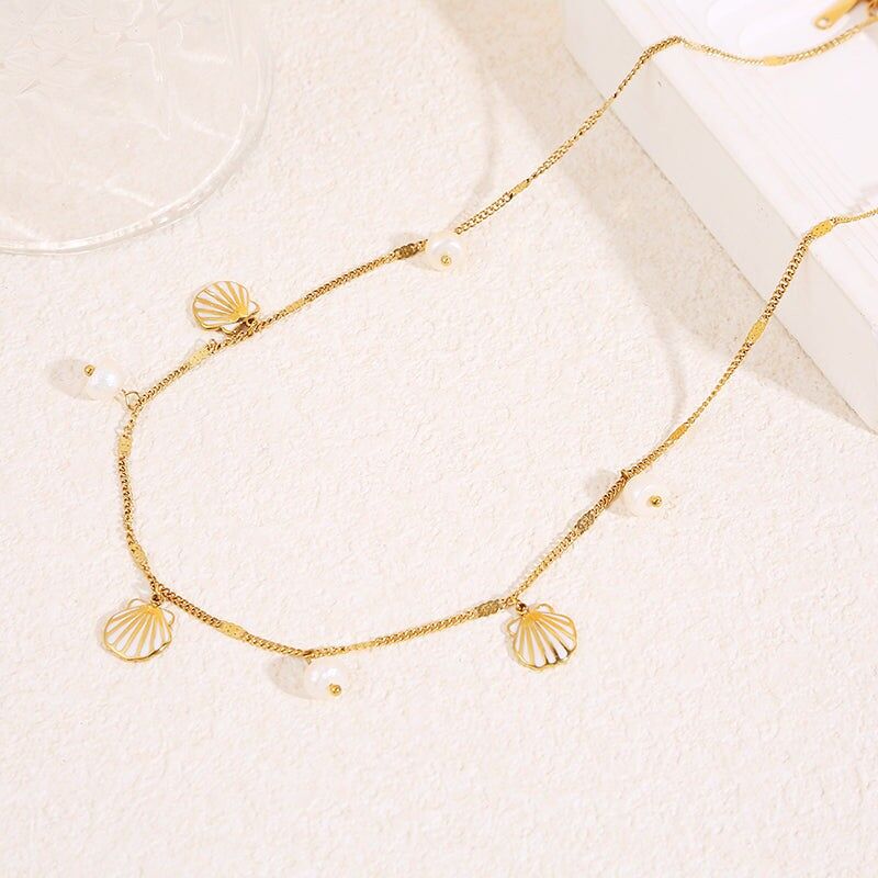 Feine Goldkette mit Perlen- und weißen Muschelanhängern