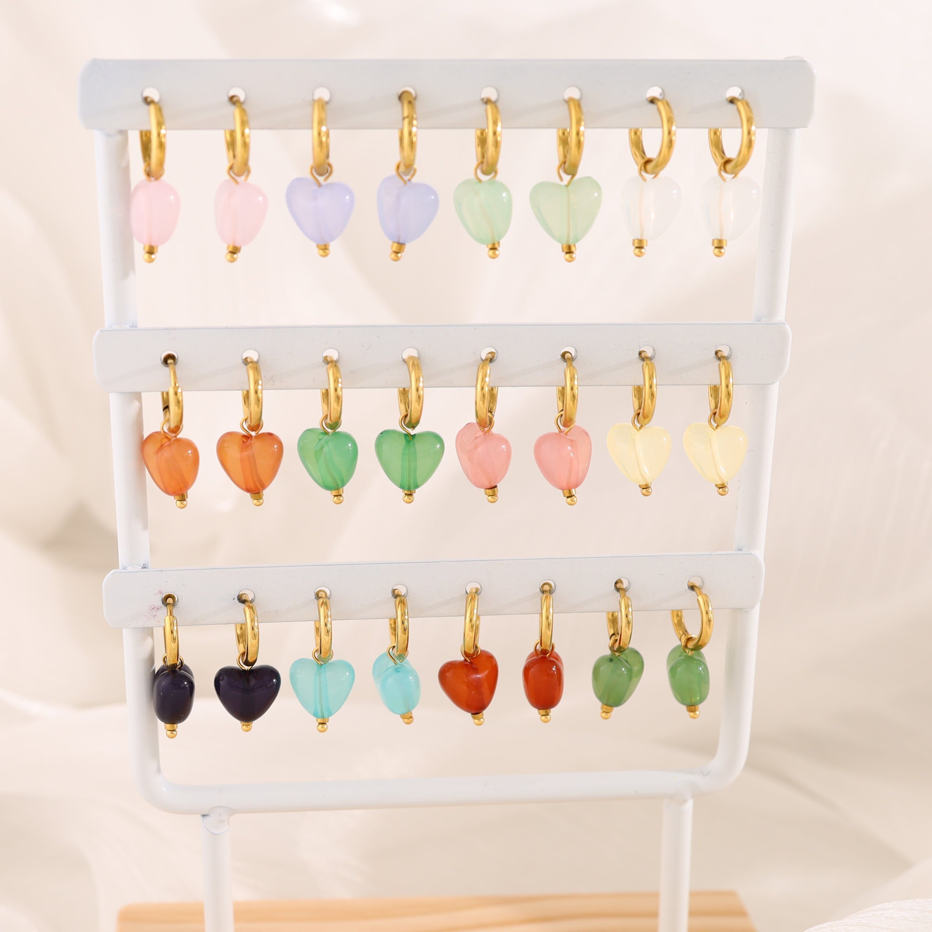 Set mit 12 Paar bunten Mini-Herz-Creolen auf weißem Display