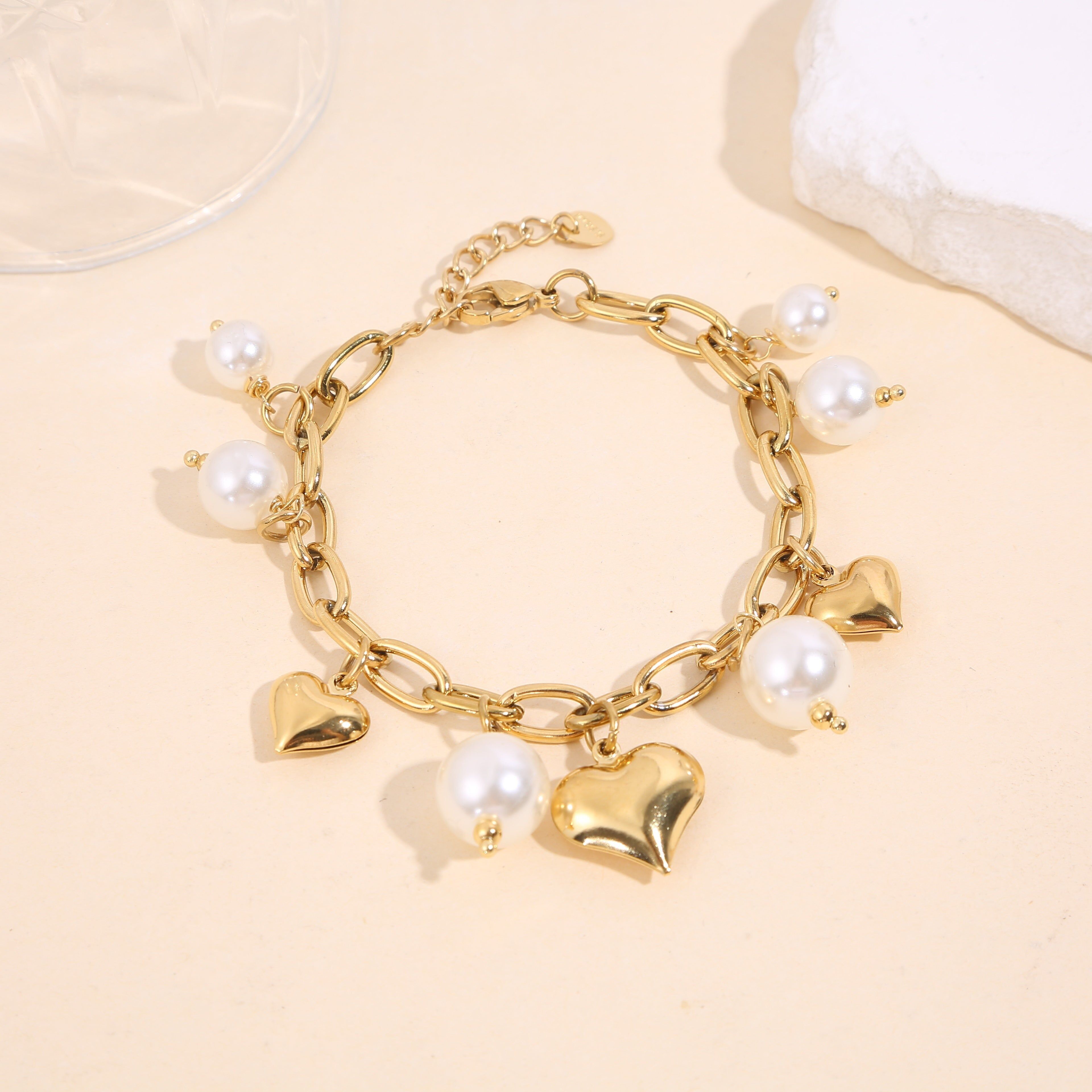 Bracciale a maglie in oro con ciondoli a forma di cuore e perla