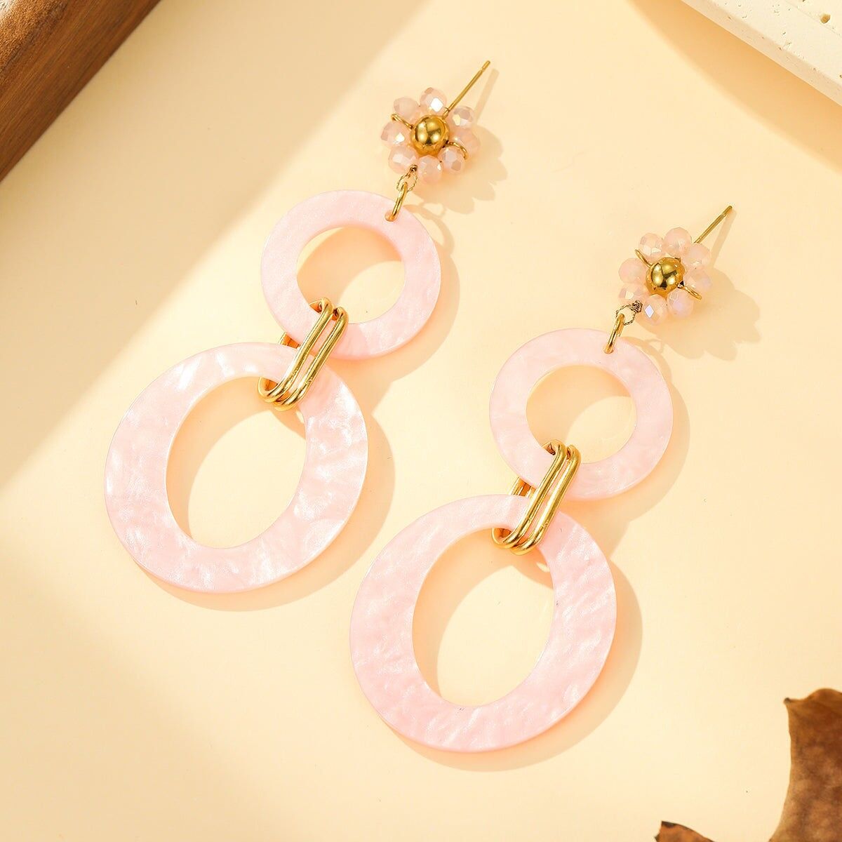 Orecchini pendenti in resina rosa con maglie ovali e fiore di perle