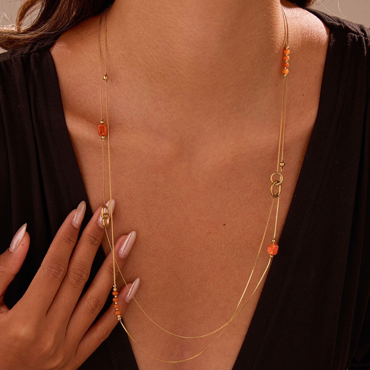 Collana Sautoir pregiata con perline arancioni e dettagli ad anello in oro