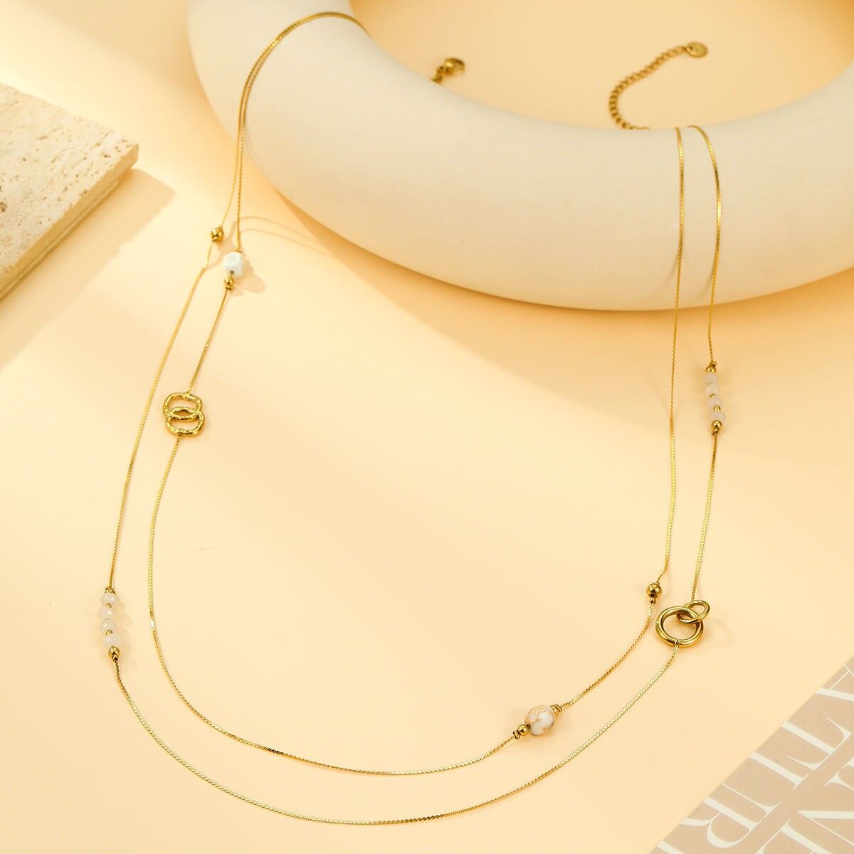 Collana Sautoir pregiata con perle bianche e dettagli ad anello in oro