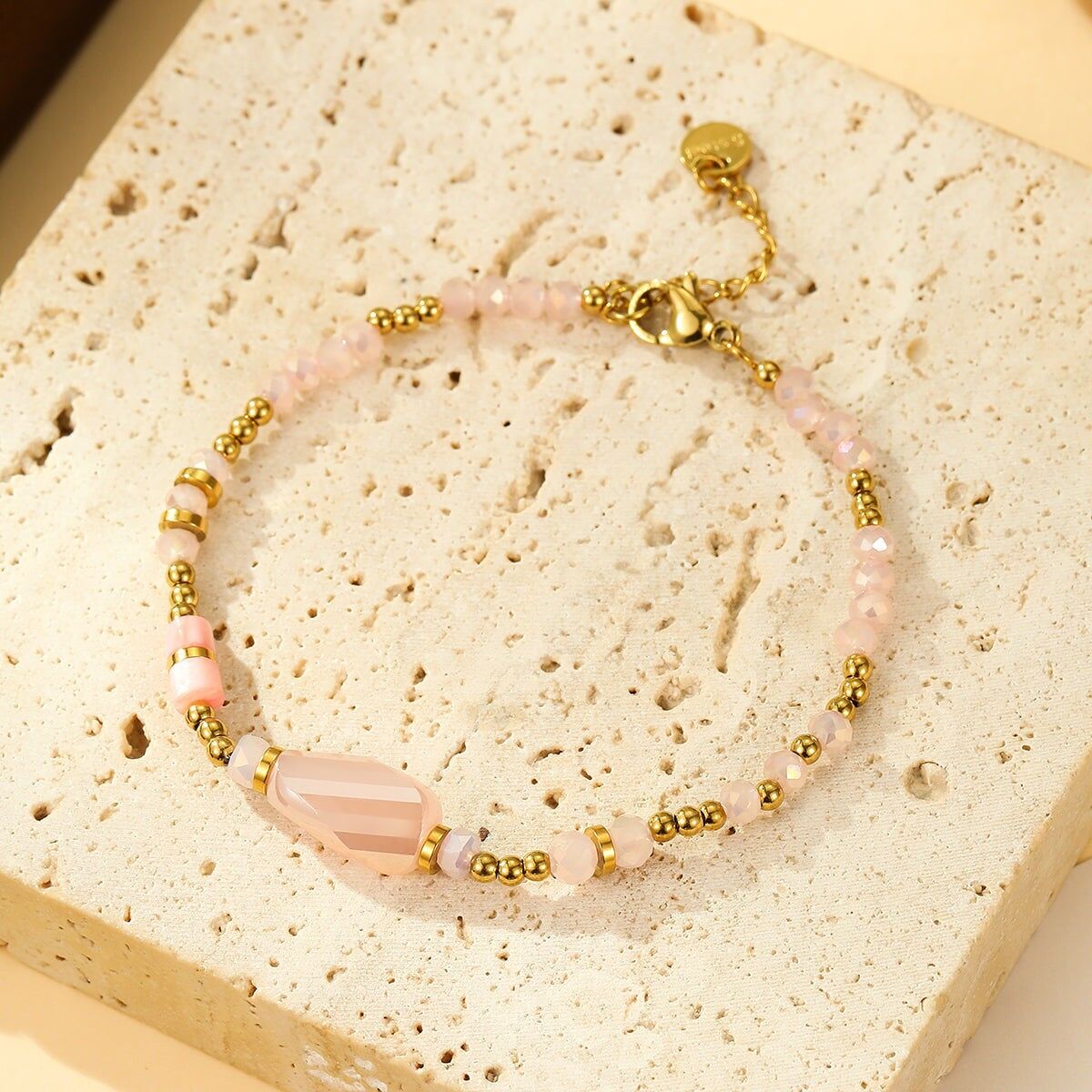 Bracciale in perle rosa e oro con pietra centrale sfaccettata
