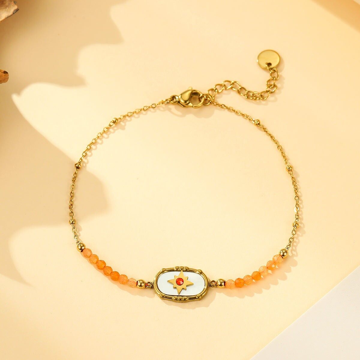 Bracciale in oro con medaglione a stella, strass e pietre di corniola