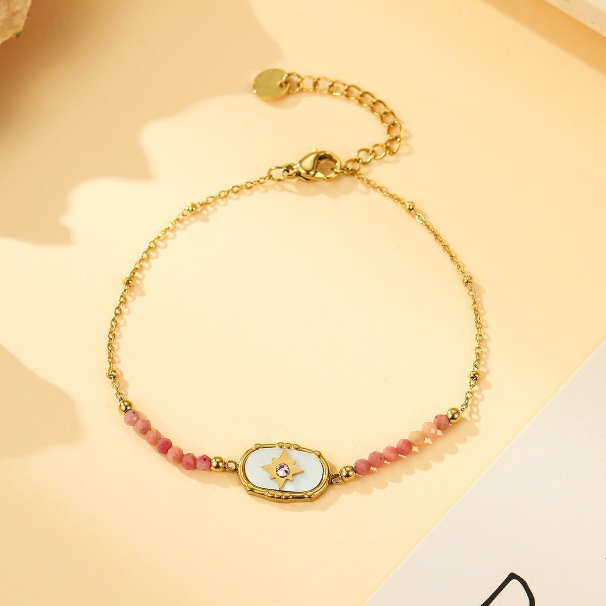 Bracciale in oro con medaglione a stella, strass e pietre di rodonite