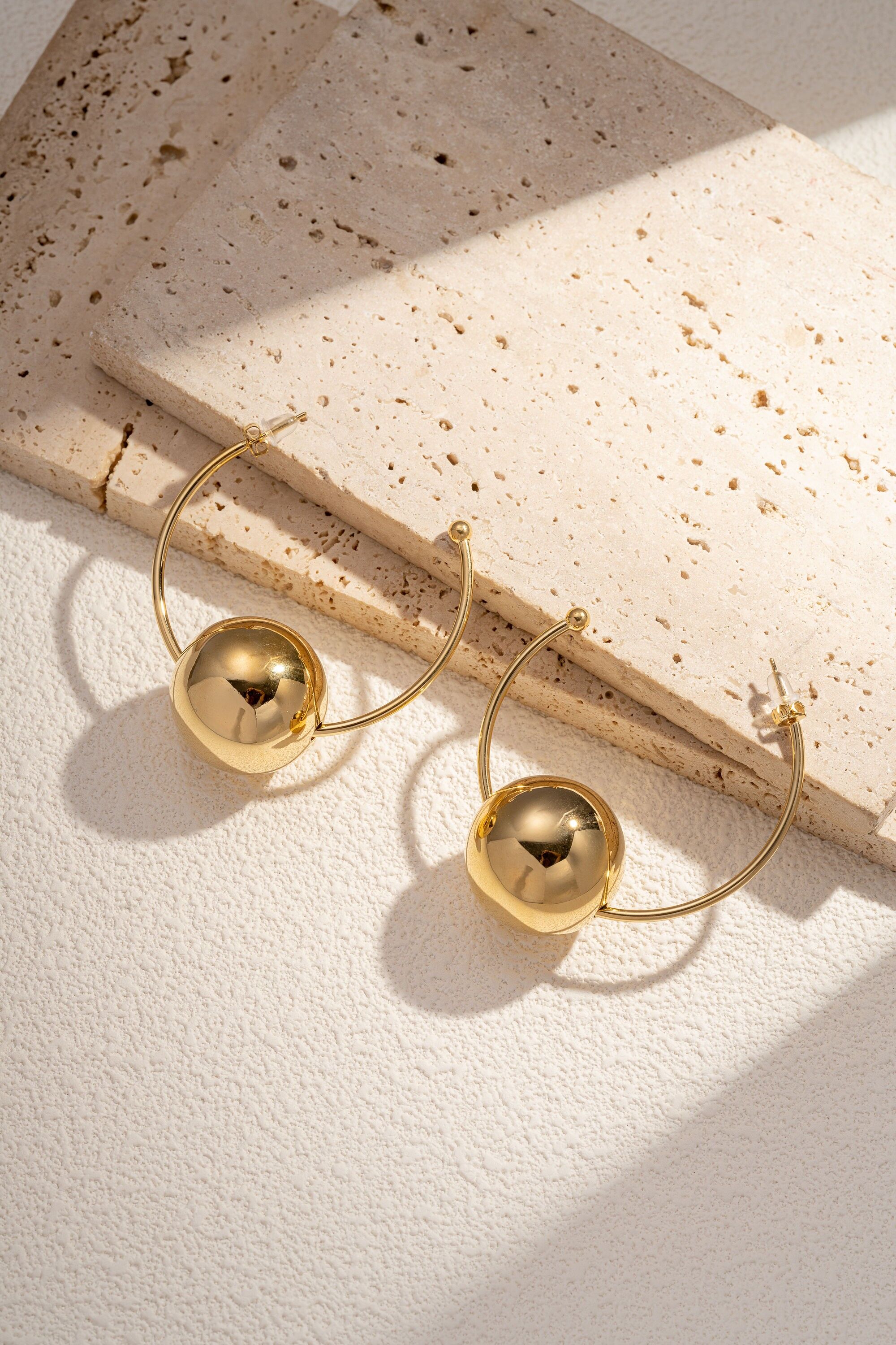 Un criollo de moda en acero inoxidable bañado en oro, realzado con una bola central.