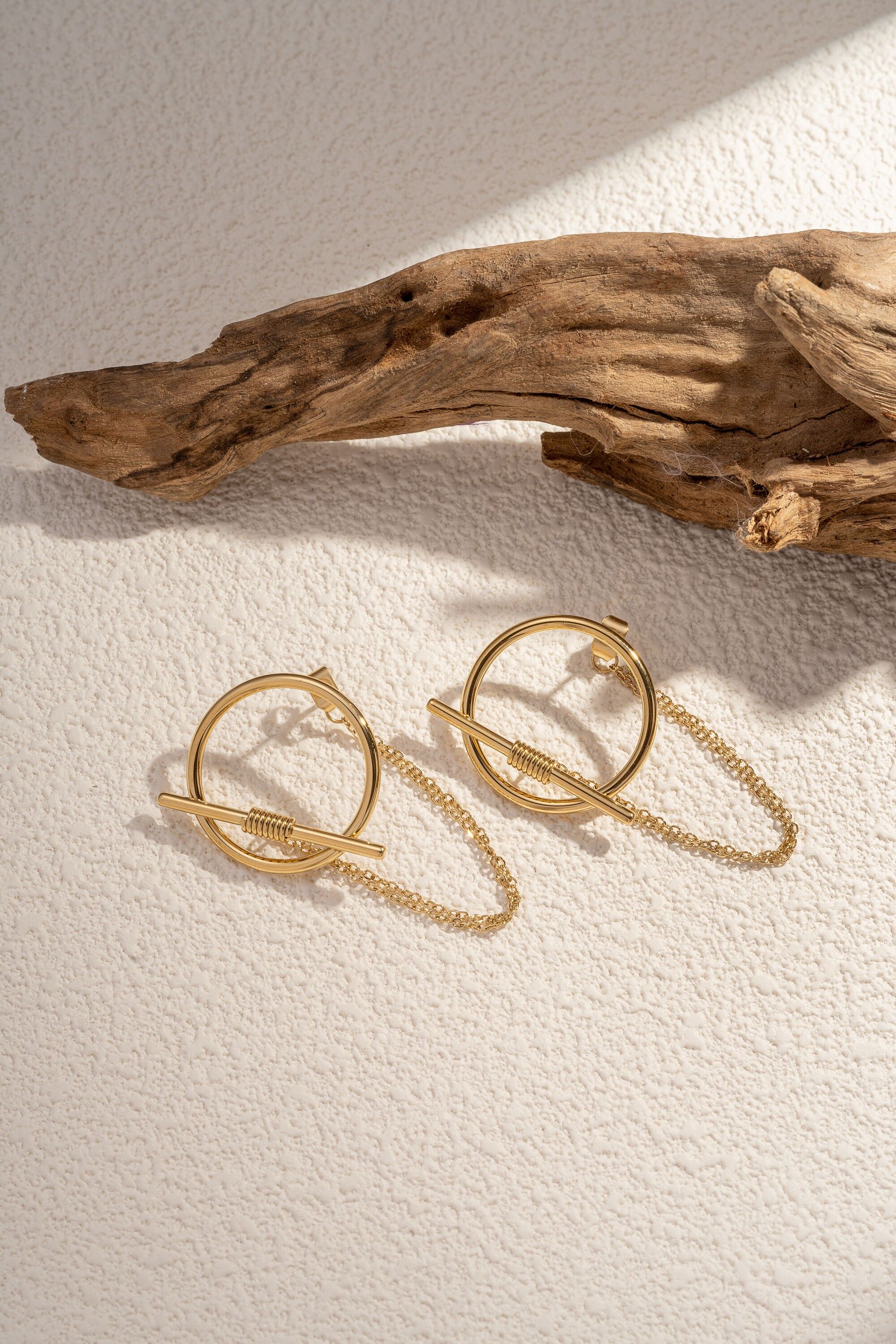 A pretty stainless steel earring features a round pattern