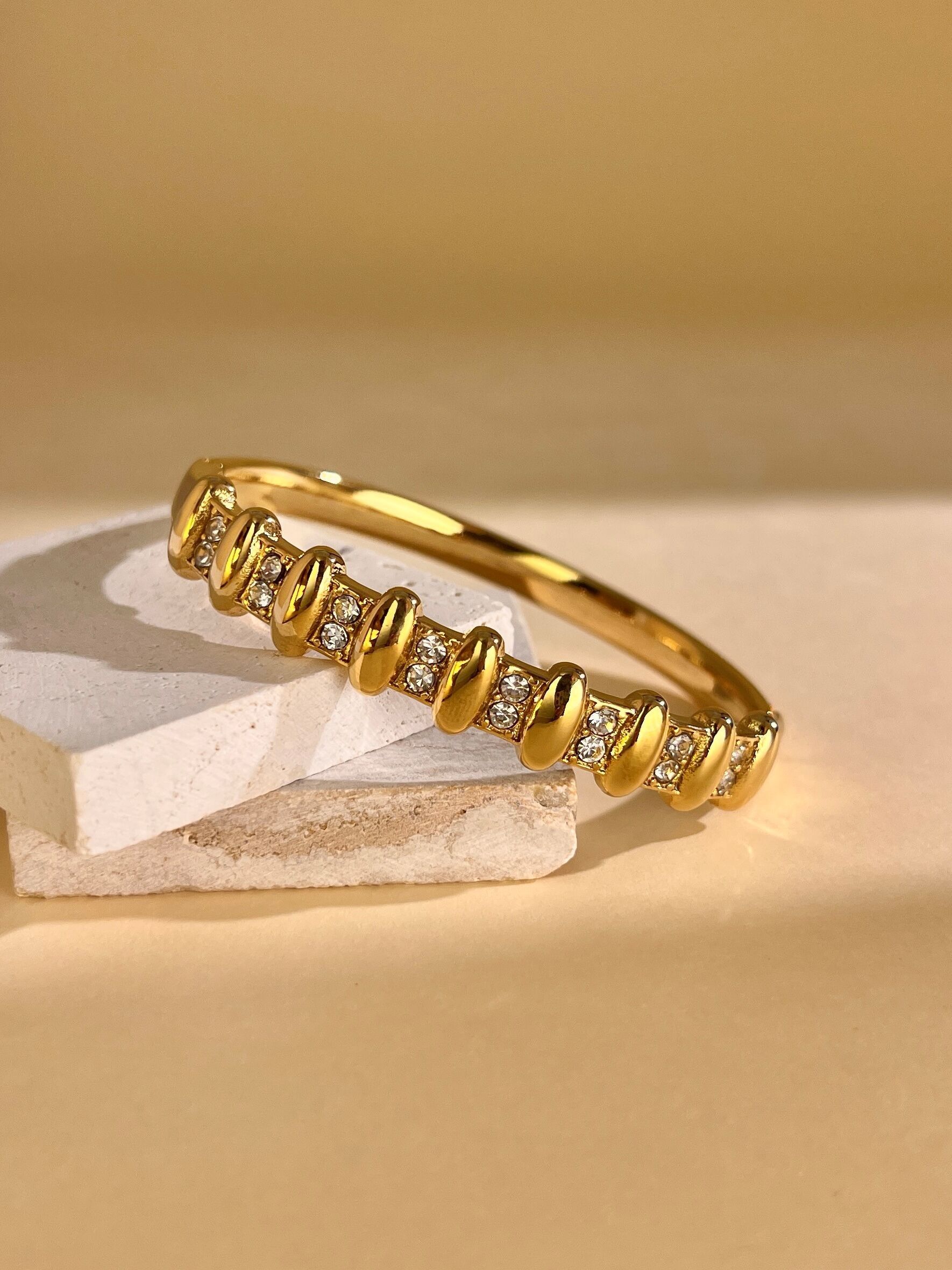 Pulsera de acero inoxidable con dos hileras de diamantes de imitación dorados.