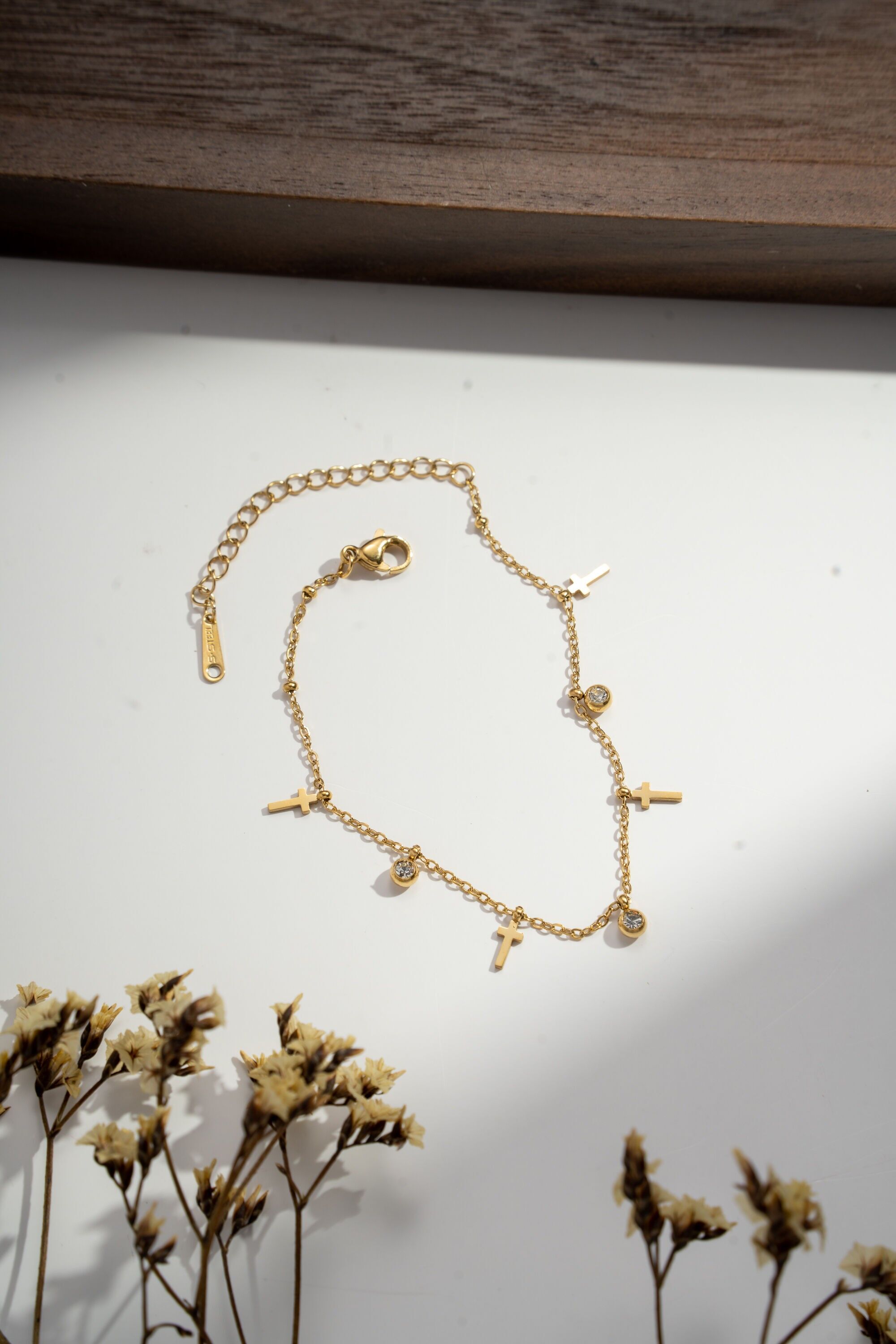 Pulsera refinada con cruz y dije de pedrería en acero.