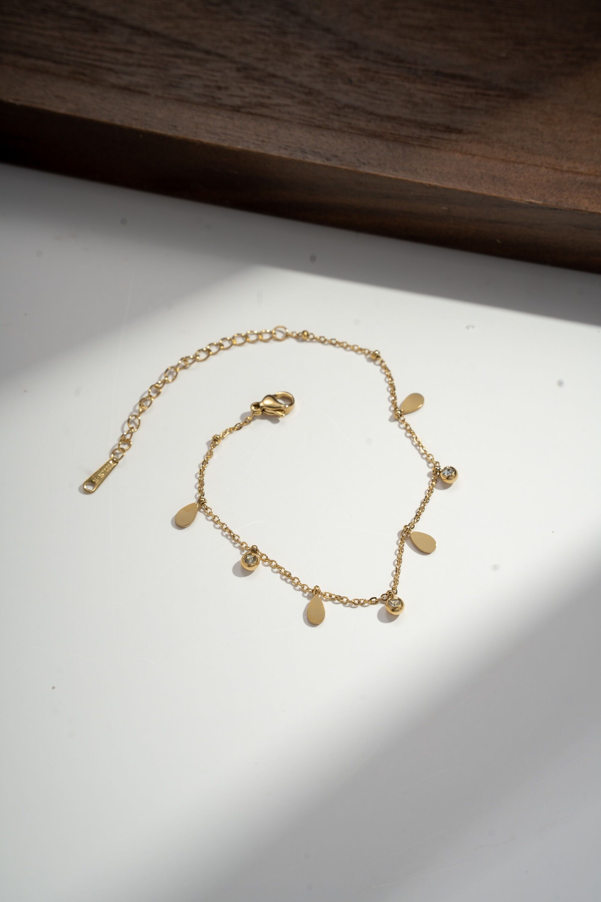 Pulsera refinada con borlas y pedrería en acero.